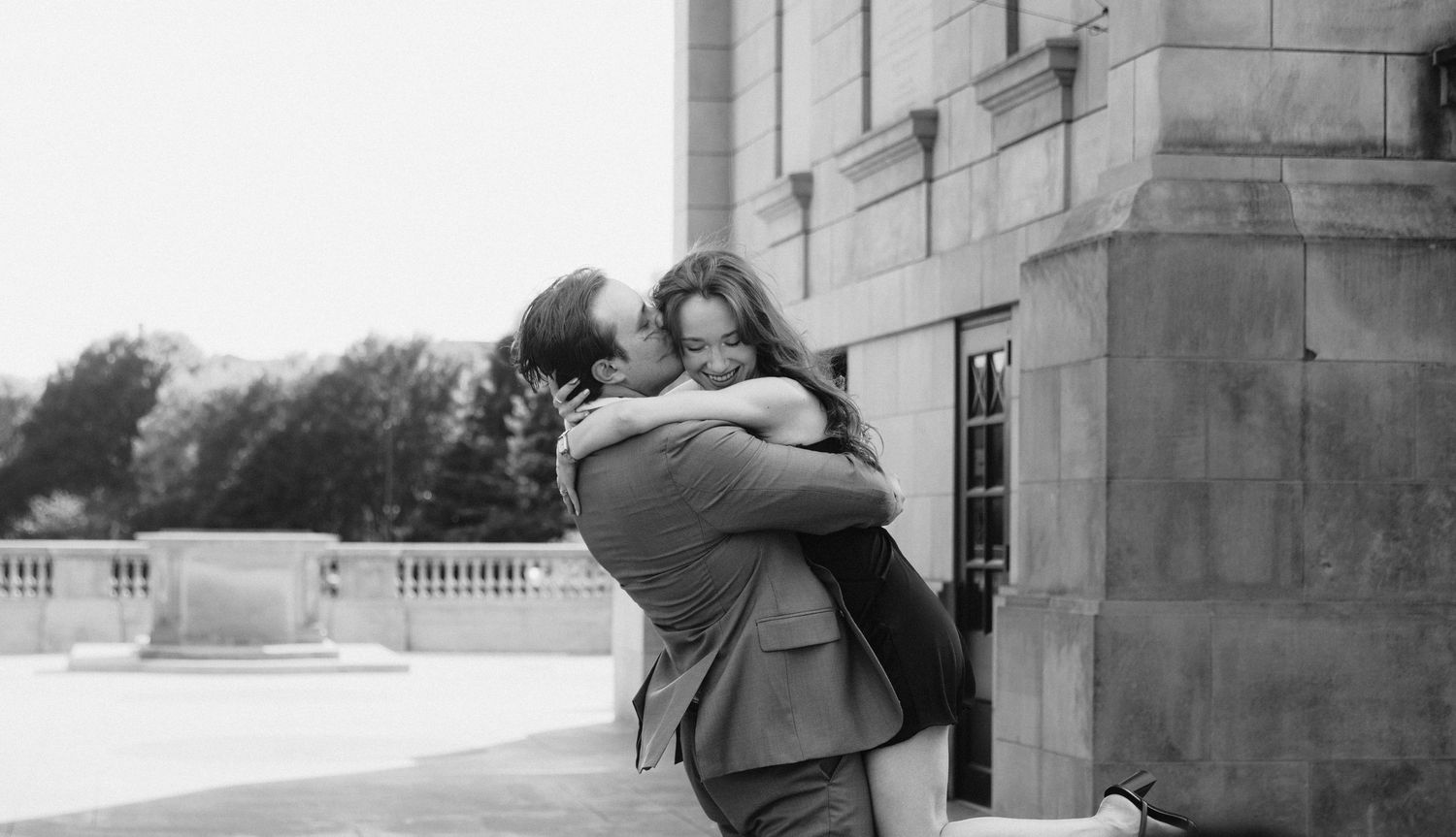 A black and white photo collage shows a couple embracing and sharing tender moments on a stone terrace.