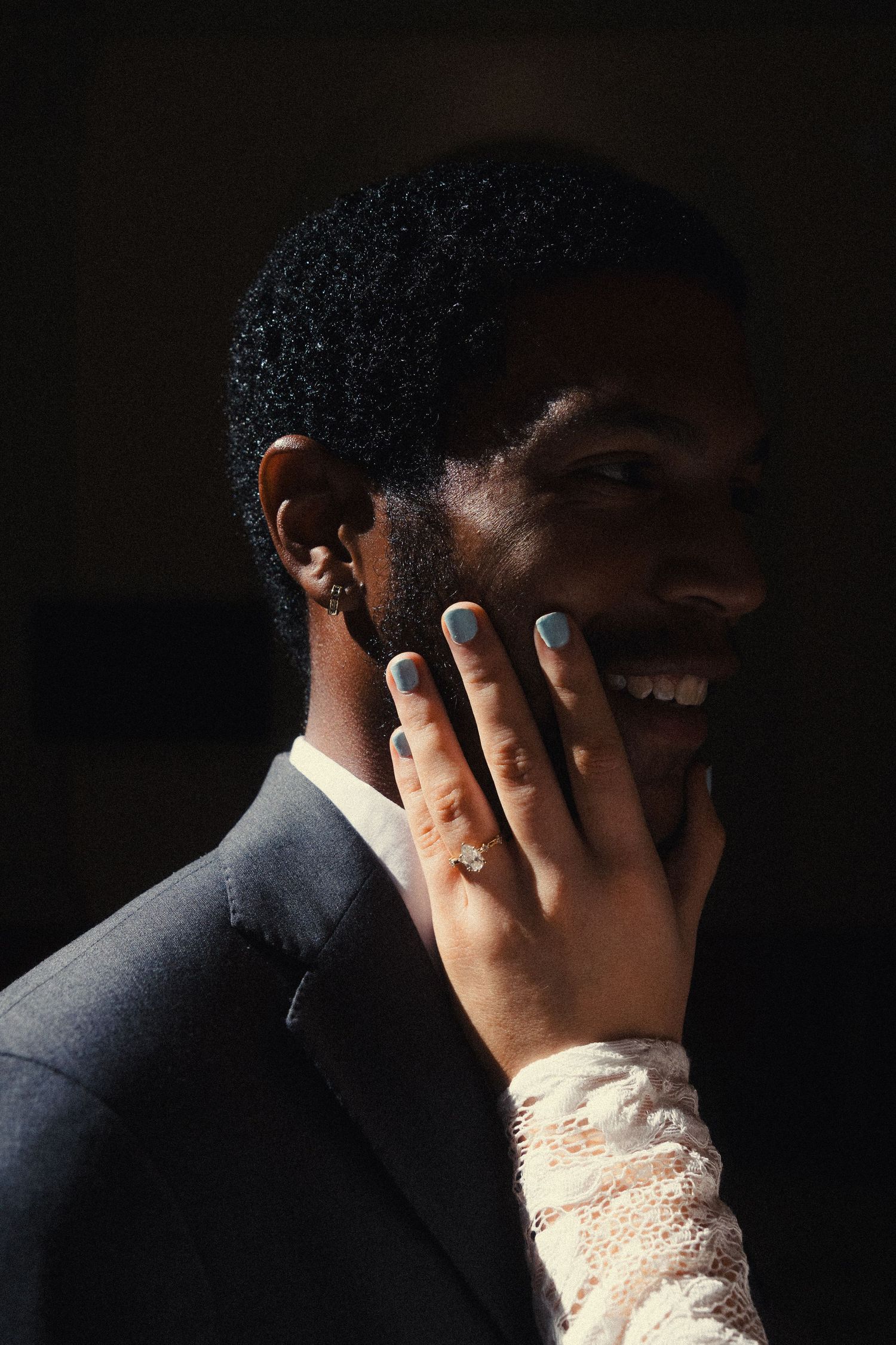 A series of intimate black and white photos showing hands with wedding rings against dark backgrounds.