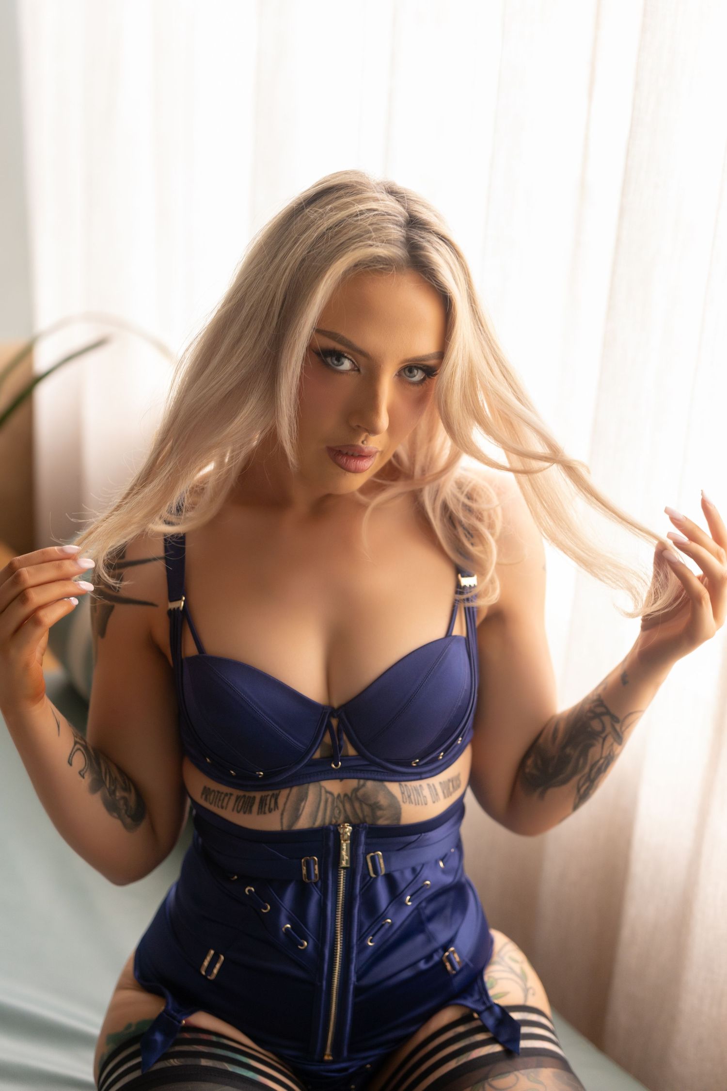 A series of boudoir photos showing someone wearing blue lingerie in soft window lighting.