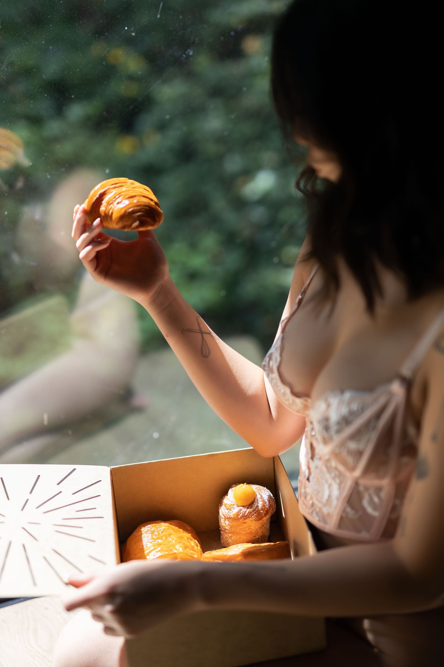 A person in a white dress sits at a table breaking bread or pastries in a series of sequential images.