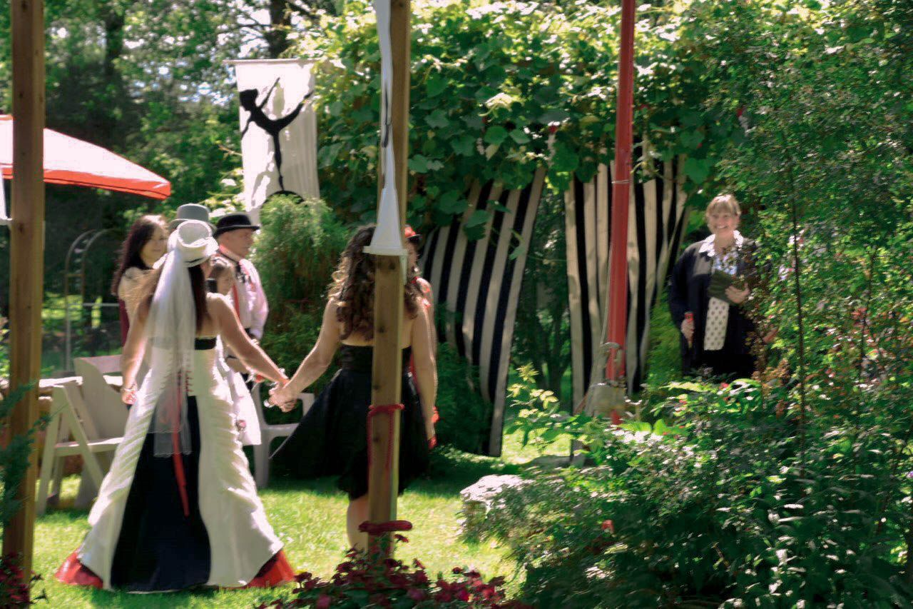 Bride and her mother walk down the isle at a circus themed intimate backyard wedding at their home in Niagara.