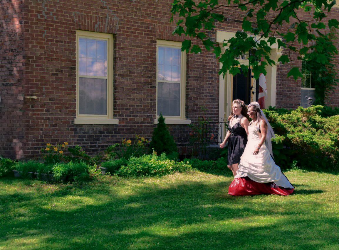 Bride and her mother walk down the isle at a micro wedding at their home in Niagara.