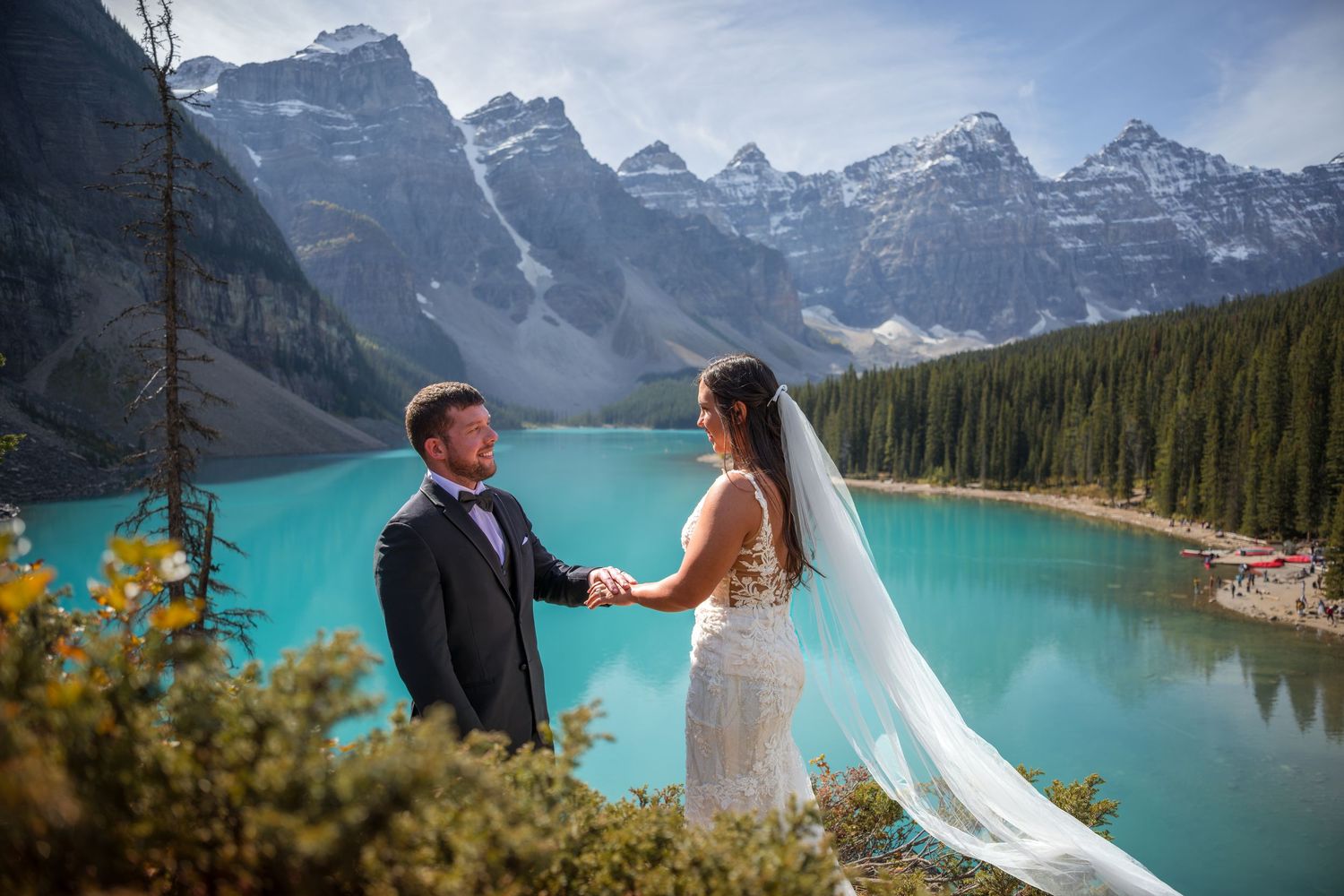 Couple exchanges vows at Moraine Lake, Banff, with turquoise waters and Rocky Mountain peaks in the background.