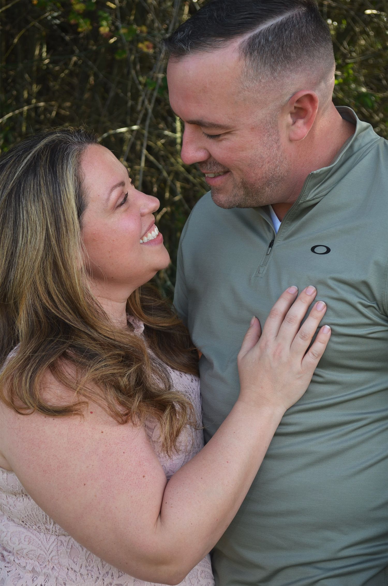 Couple gazing at each other outdoors in warm light.