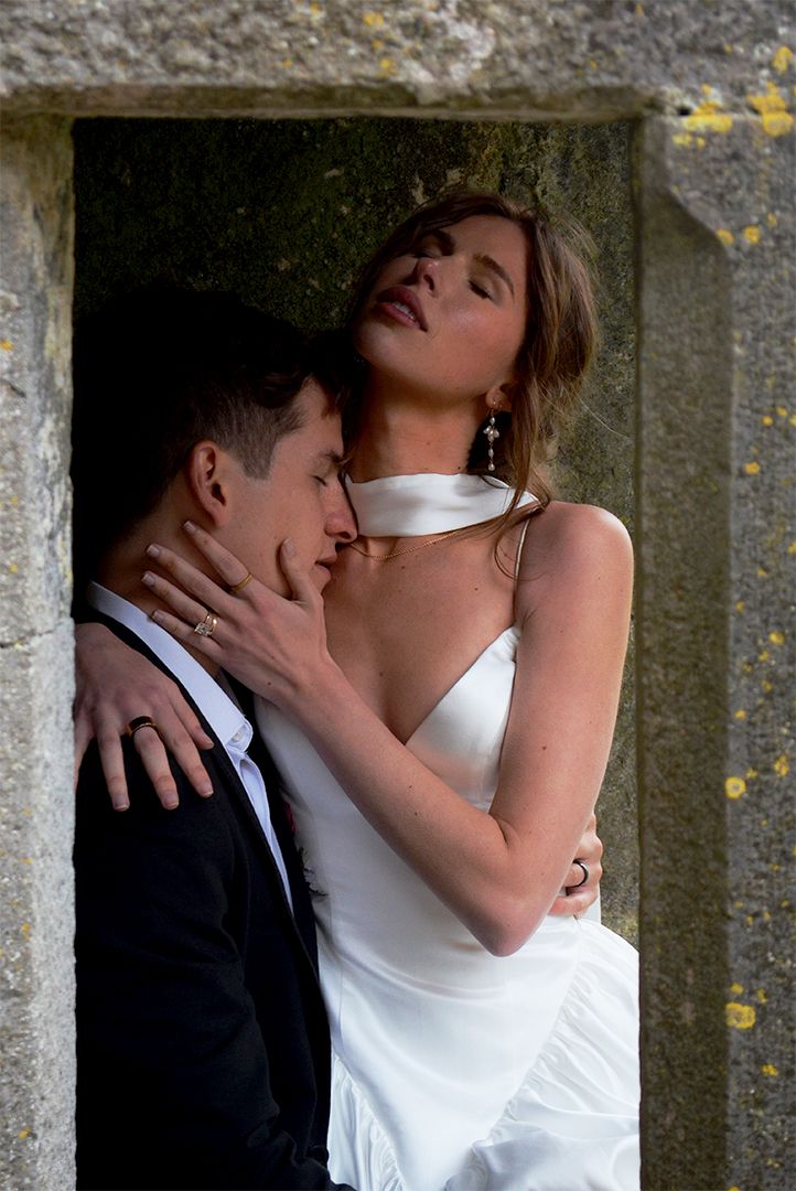 Couple posing in stone doorway in formal attire.