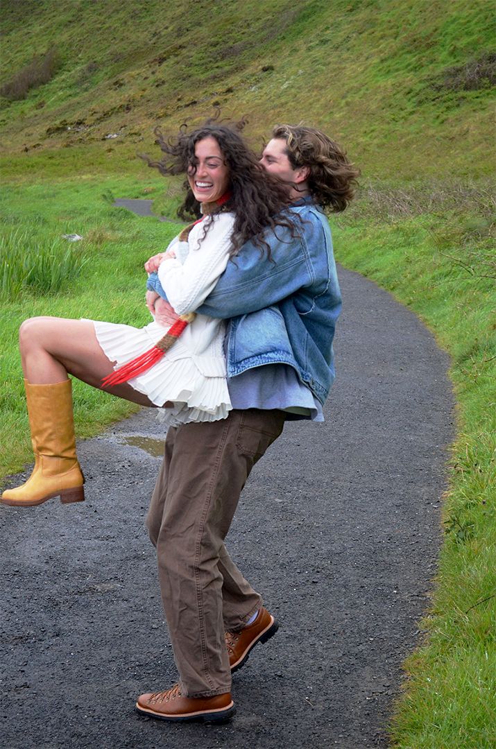 Couple laughing on countryside path.
