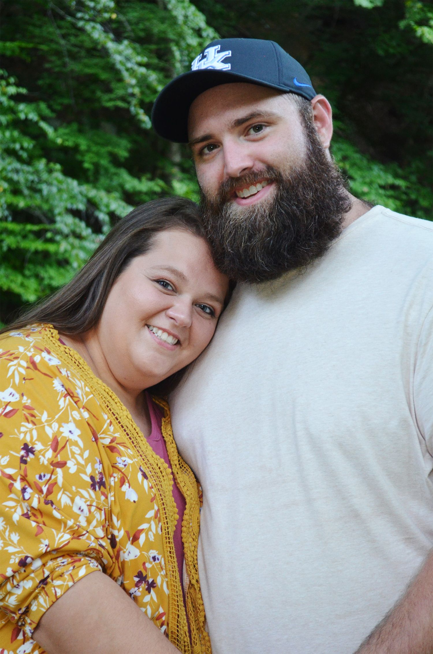 Couple smiling while cuddling close.