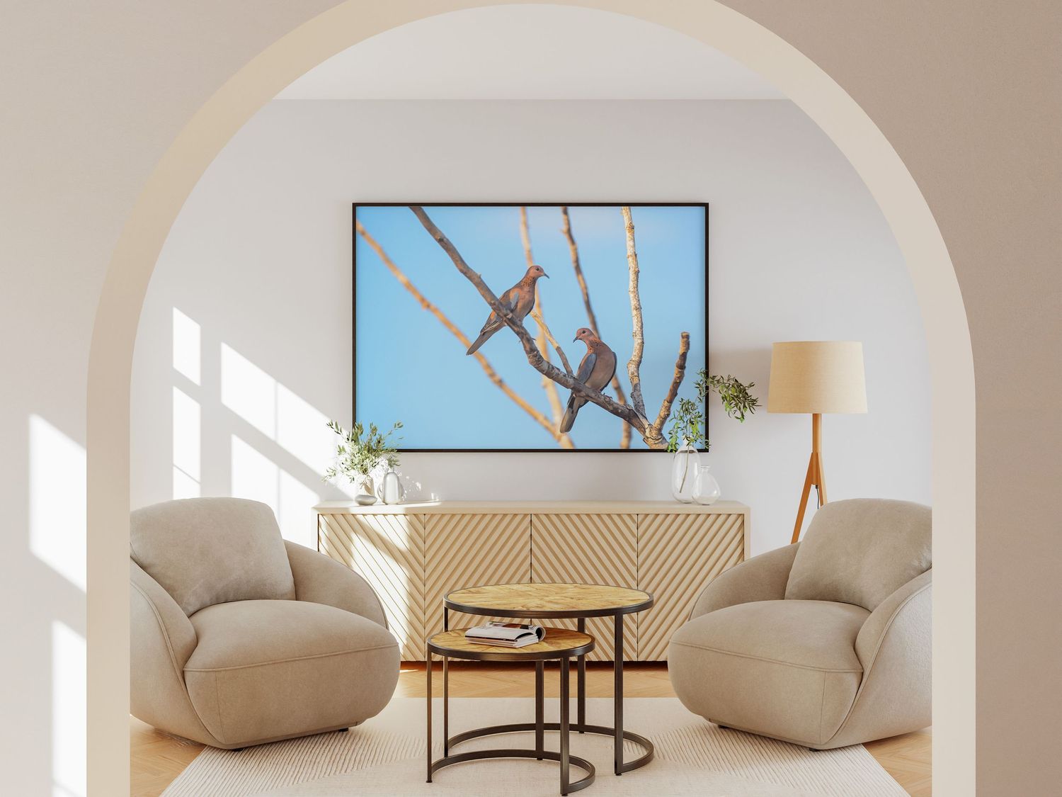 Two birds perched on branches against a blue sky in a large framed print displayed in an elegant arched living room.