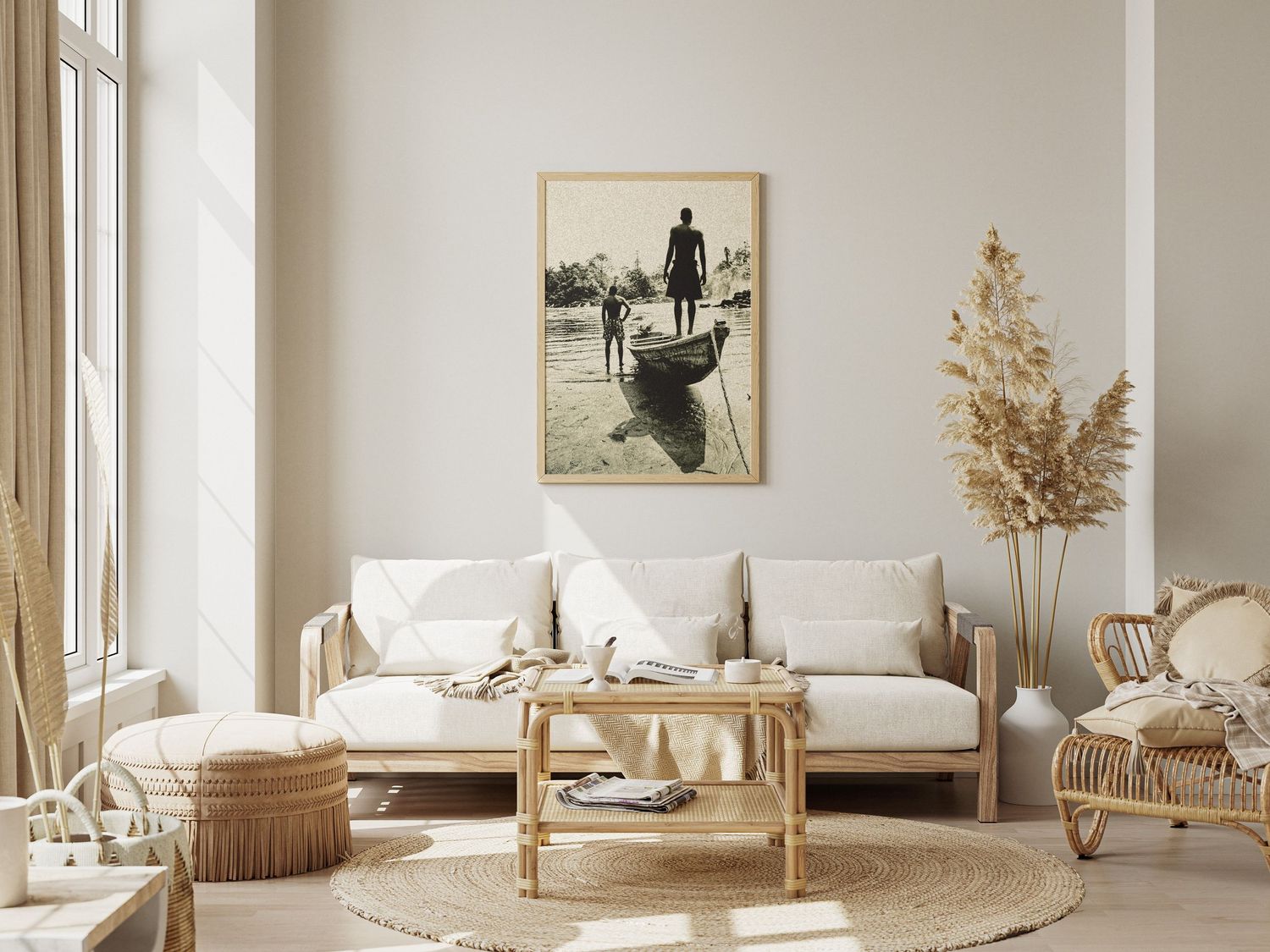 Framed black and white photo of figures near a boat displayed above a white sofa in a bohemian living room.