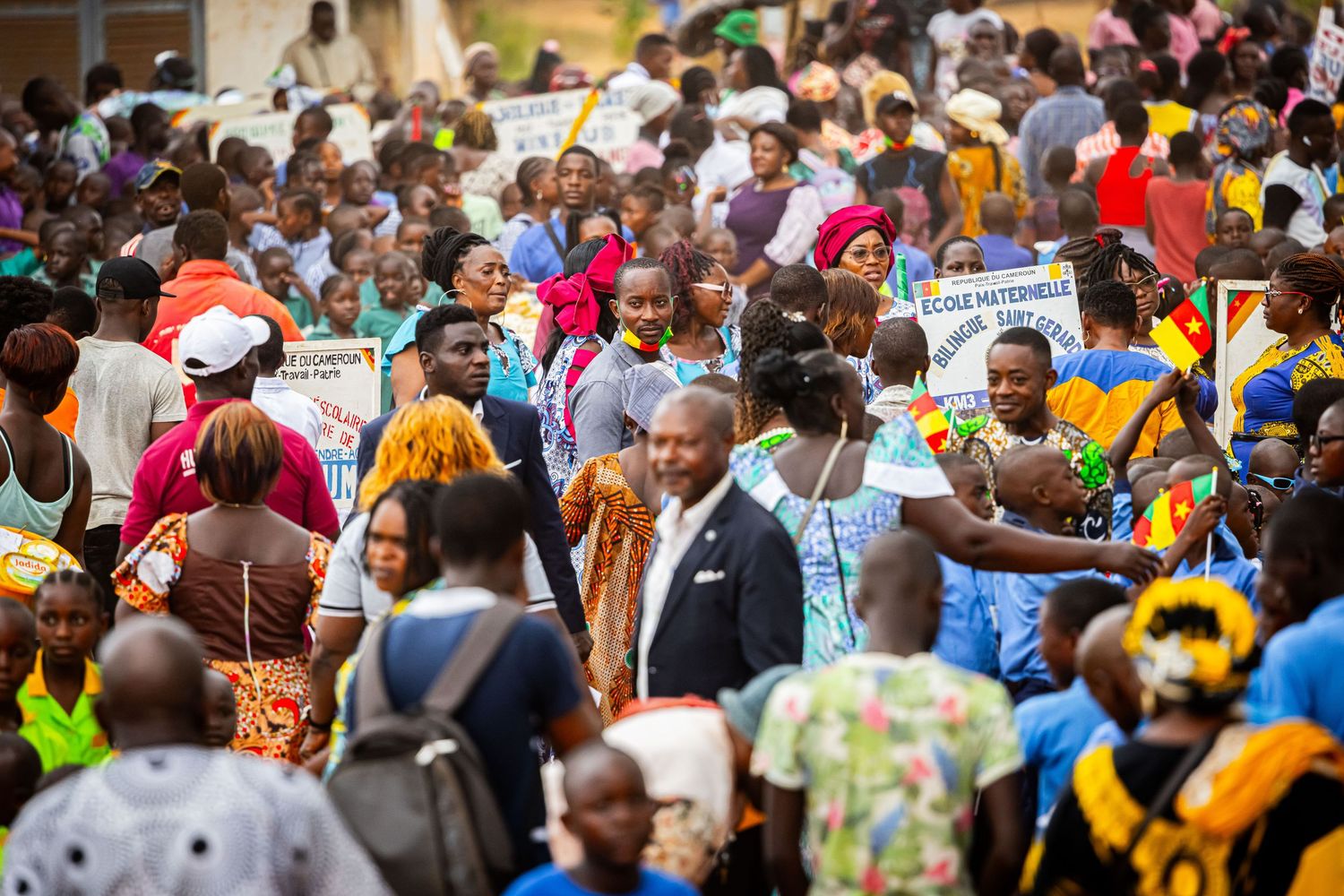 A large diverse crowd of African people gathered outdoors at a community public event.