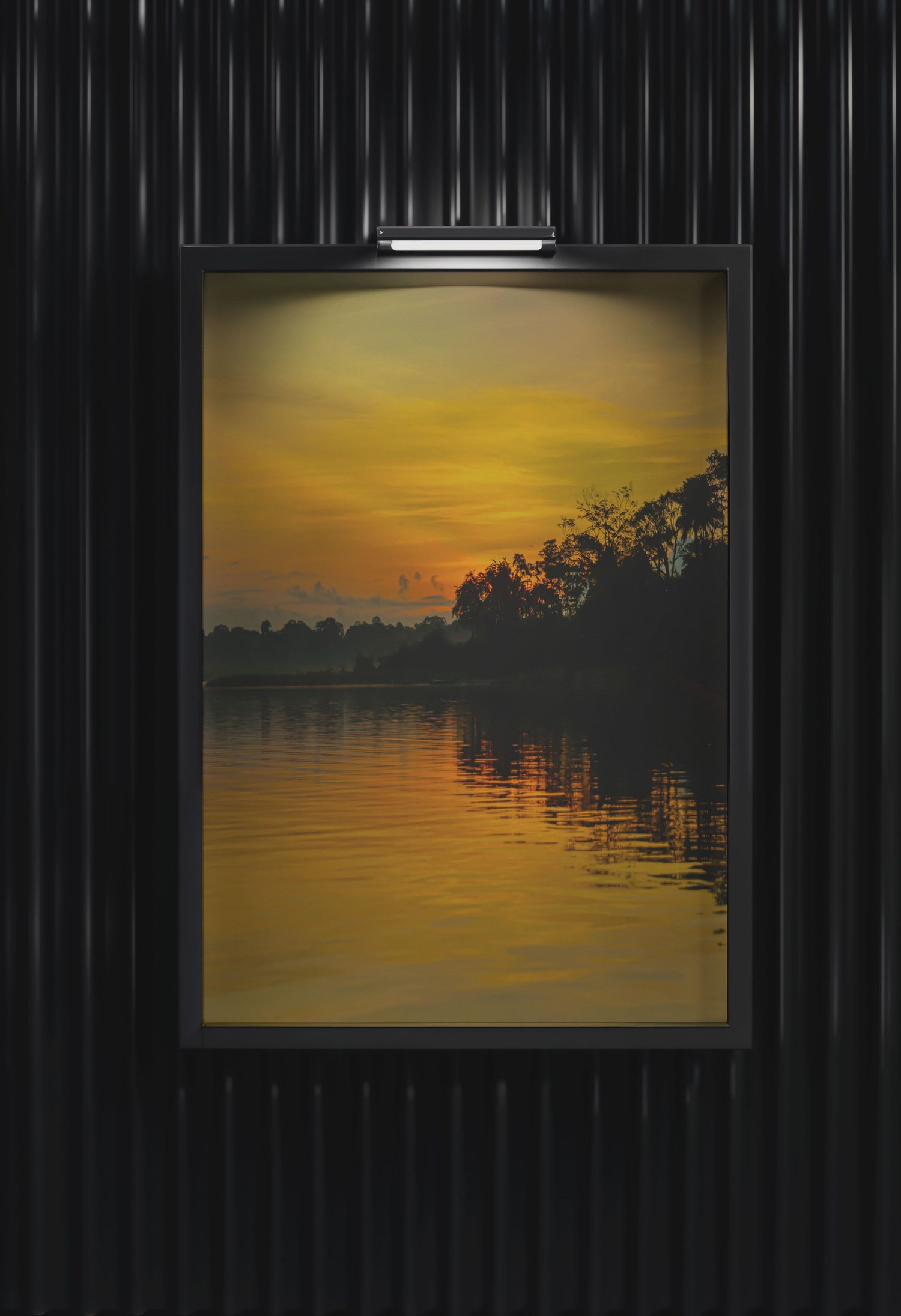 Framed sunset landscape painting with golden sky reflecting on calm water, displayed on dark wall with spotlight.