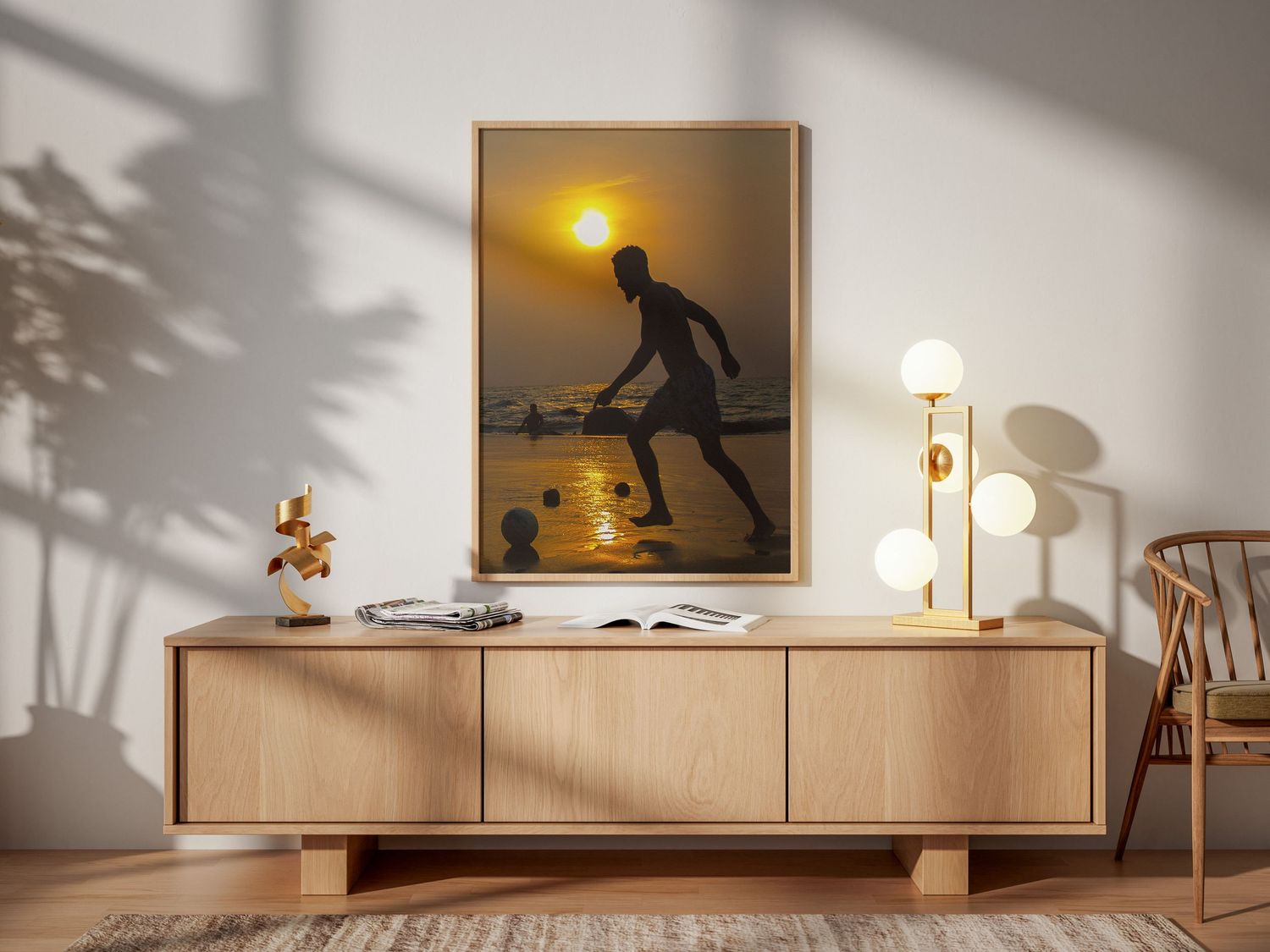 Framed silhouette photo of a soccer player at sunset displayed above a wooden sideboard in a minimalist room.