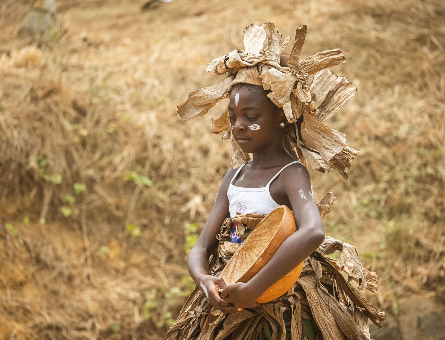 À Dizangué, lors du défilé de la Fête de la Jeunesse, elle avance avec une 
présence qui dépasse son âge. Vêtue d’une tenue traditionnelle,