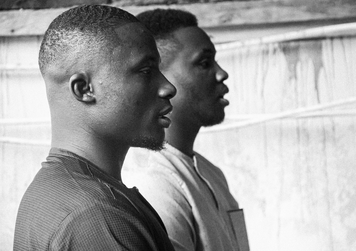 Black and white profile portrait of two young African men standing side by side.