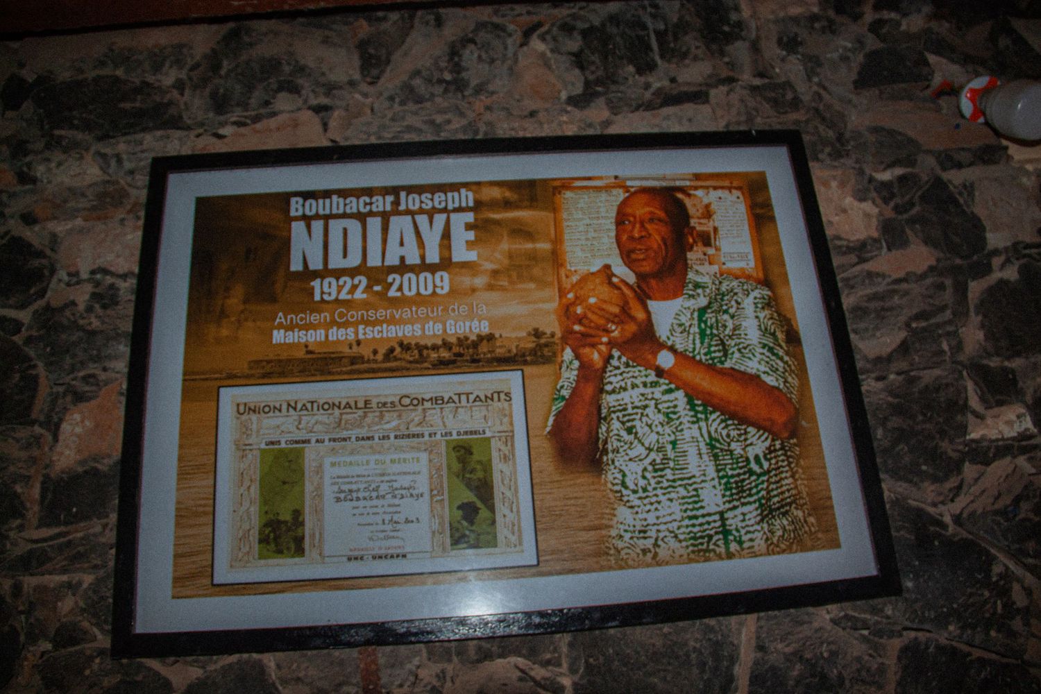 Framed memorial tribute to Boubacar Joseph Ndiaye 1922-2009, founder of Goree Island slave house museum.