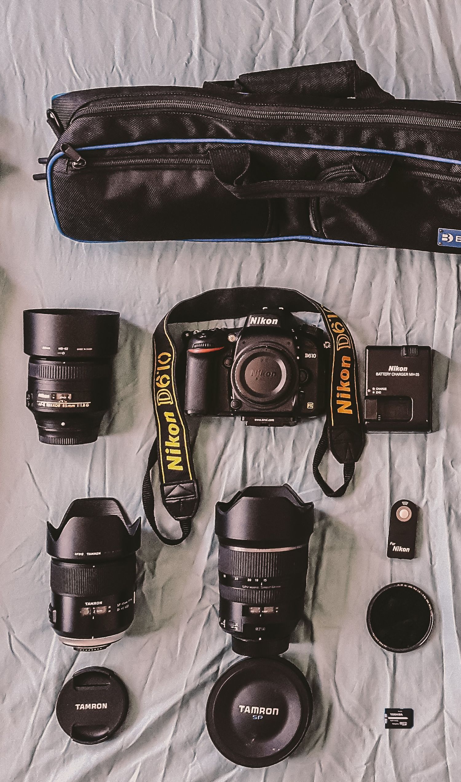 Flat lay photography camera gear layout including professional Nikon camera bodies Tamron lenses and cityscape photography kit.