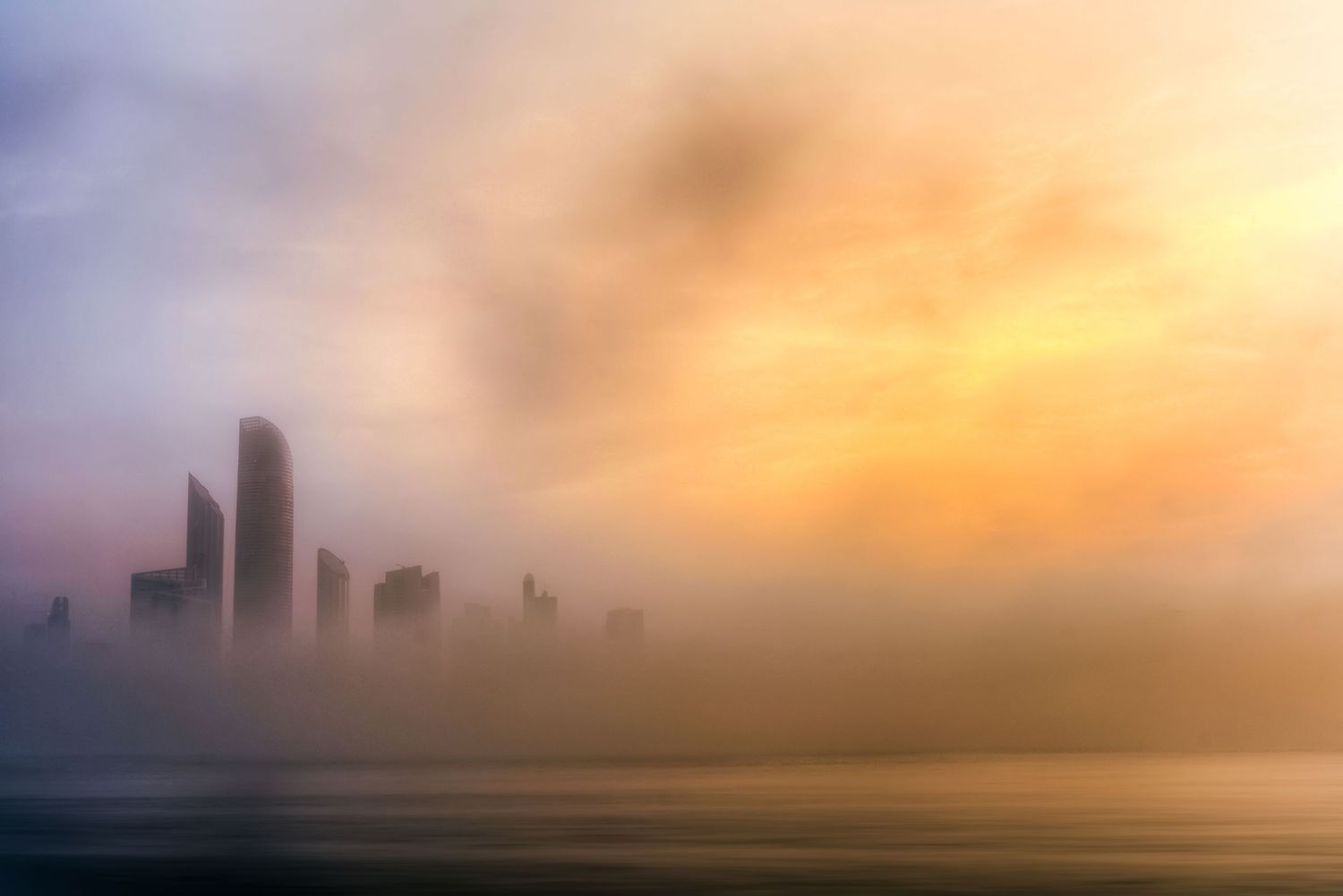 Heavy golden morning fog rolling past modern skyscraper towers Abu Dhabi Corniche UAE fine art landscape photography print.