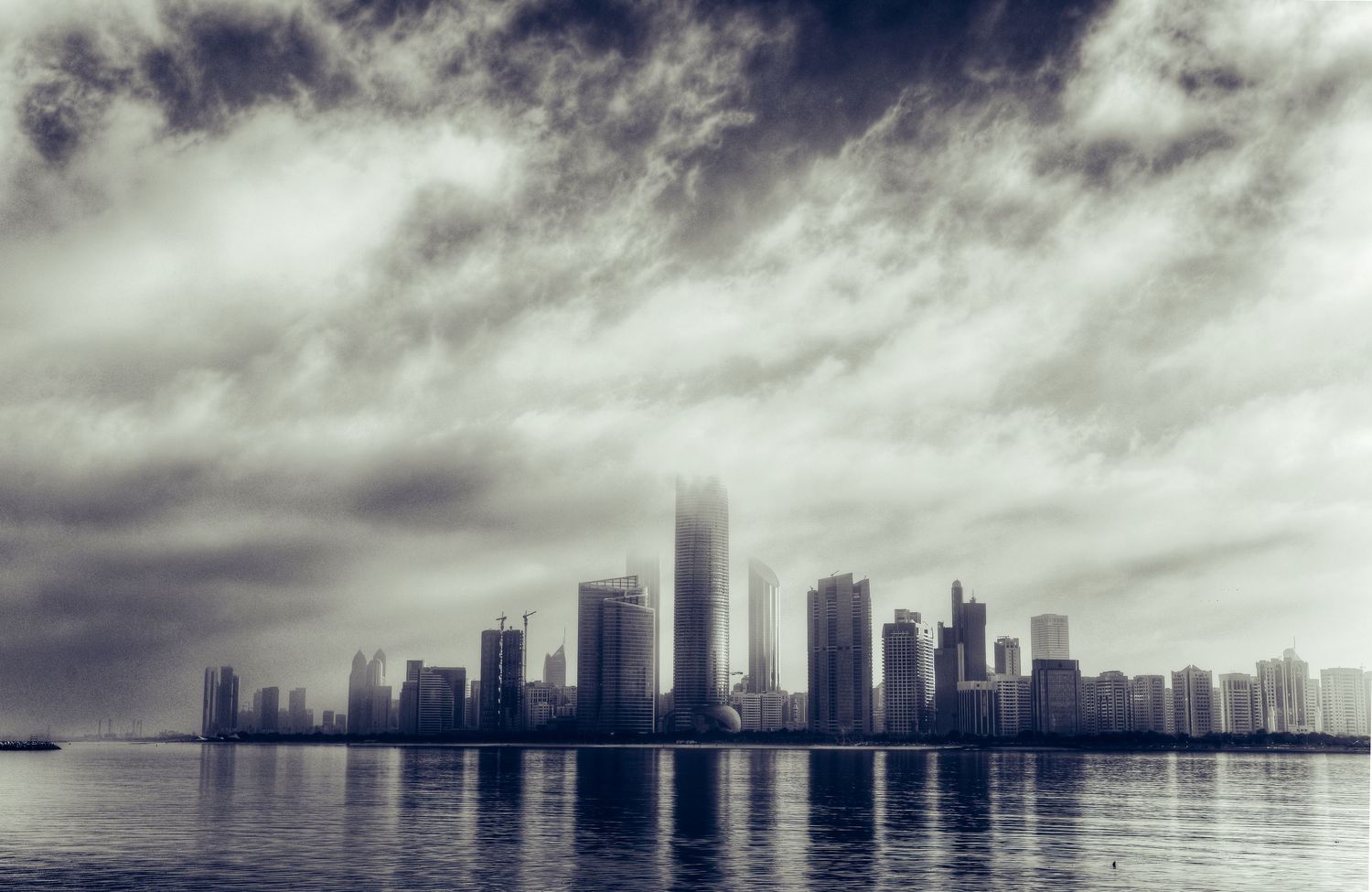 Abu Dhabi city skyline photography with dramatic dark storm clouds over modern skyscraper towers fine art monochrome prints.
