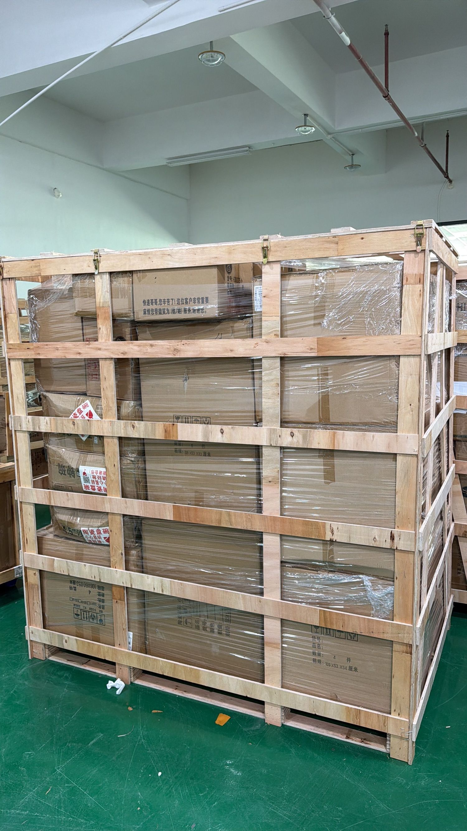 Large wooden shipping crate filled with cardboard boxes in an industrial warehouse.