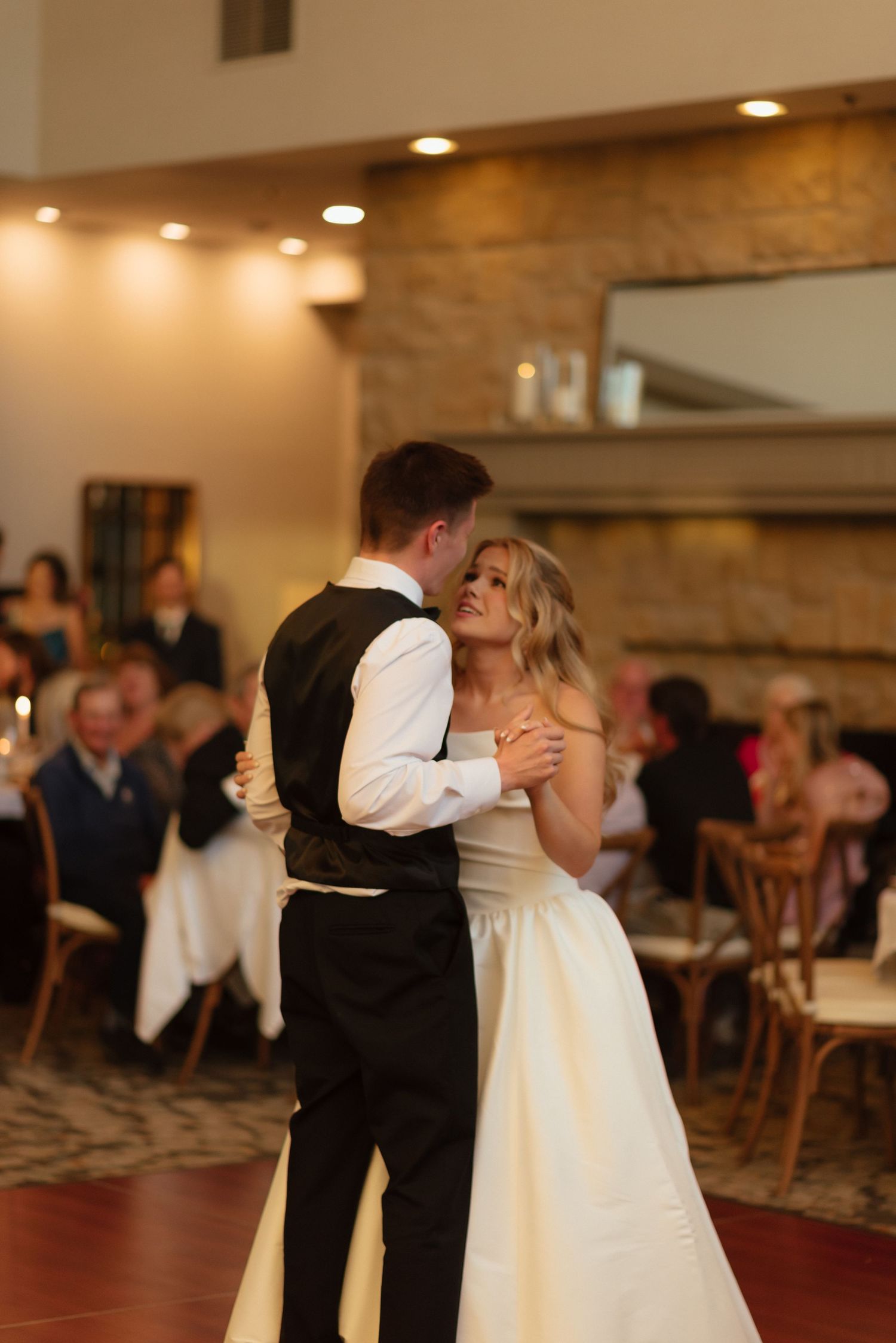 Bride and groom share their first dance at wedding reception in elegant venue.
