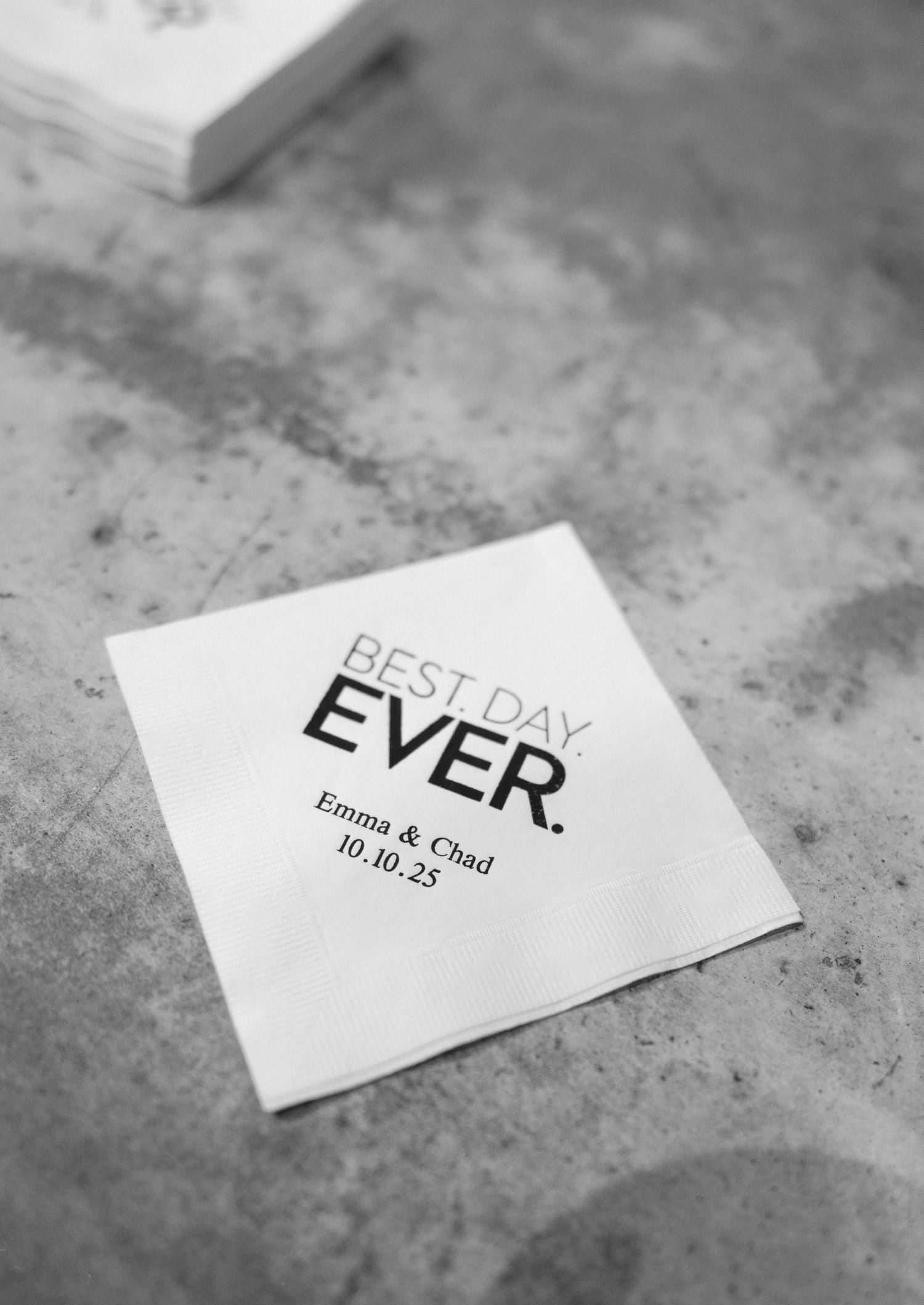 White wedding cocktail napkin printed with Best Day Ever and personalized with Emma & Chad 10.10.25.