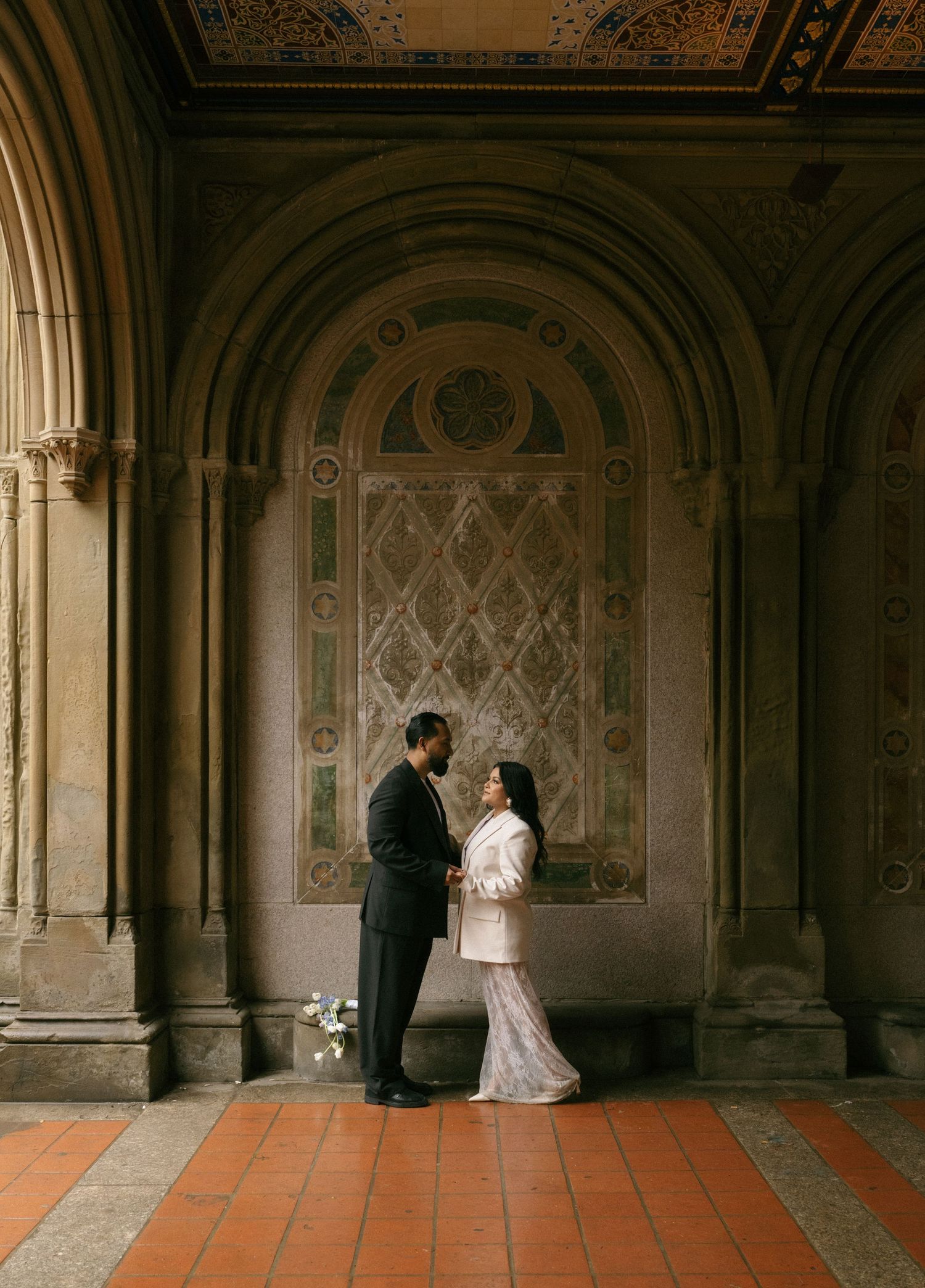 Couple sharing an intimate moment at Bethesda Terrace arcade in Central Park, NYC.