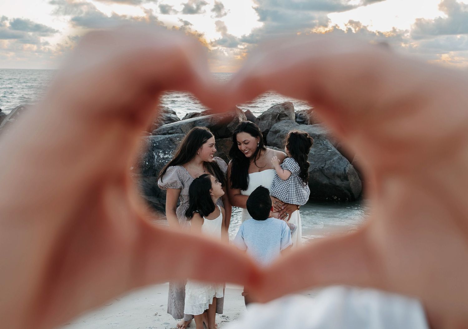 Family photos on beach in St Petersburg, Florida at sunset walking and holding hands.