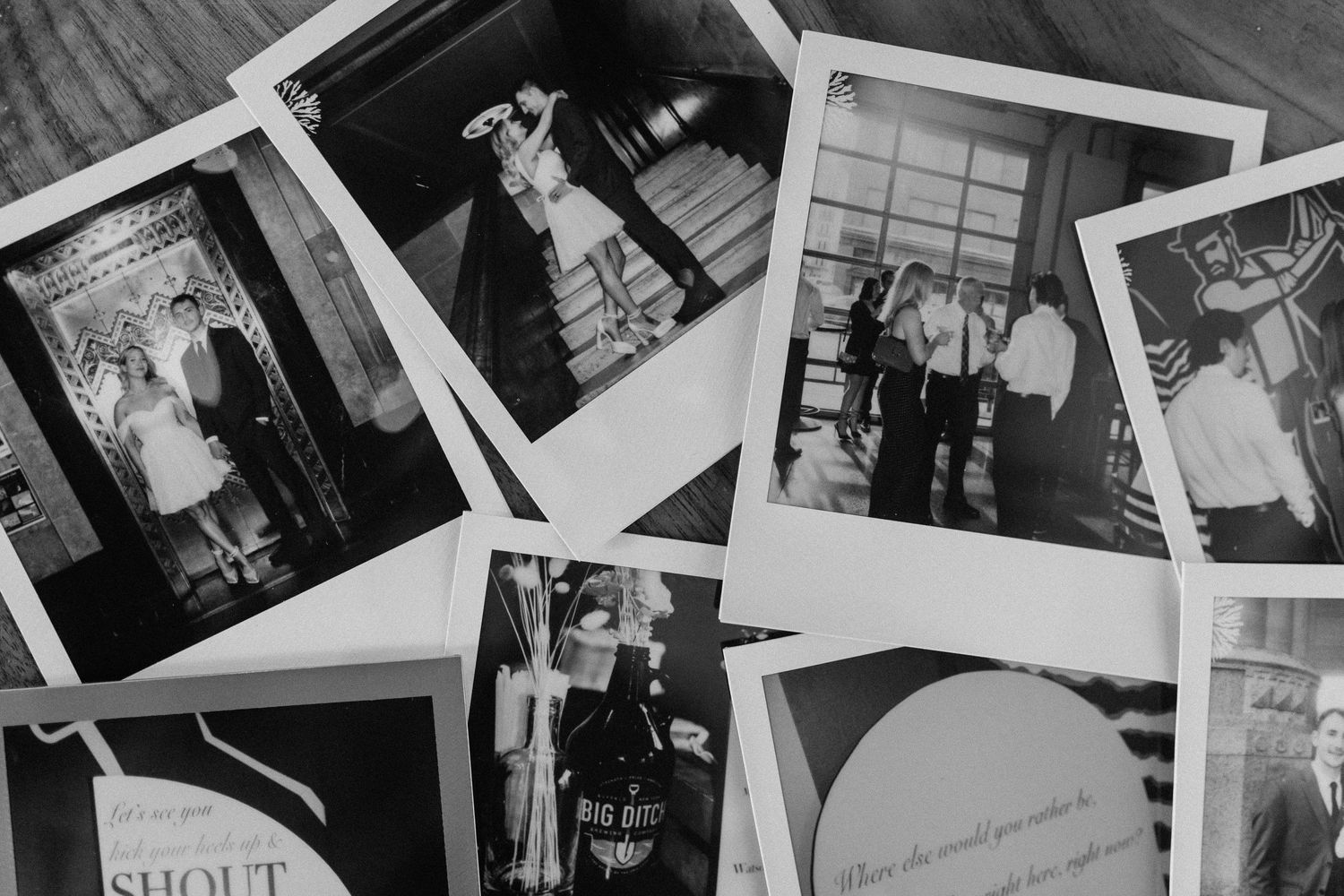 Black and white photo of scattered Polaroid wedding photos on a surface, capturing candid moments of couples and guests.