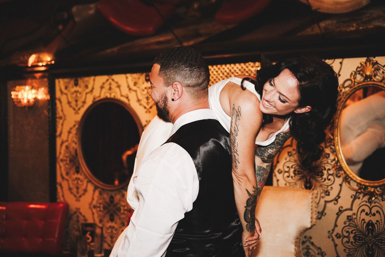 Bride and groom sharing intimate dance moment in ornate dimly lit wedding reception venue.