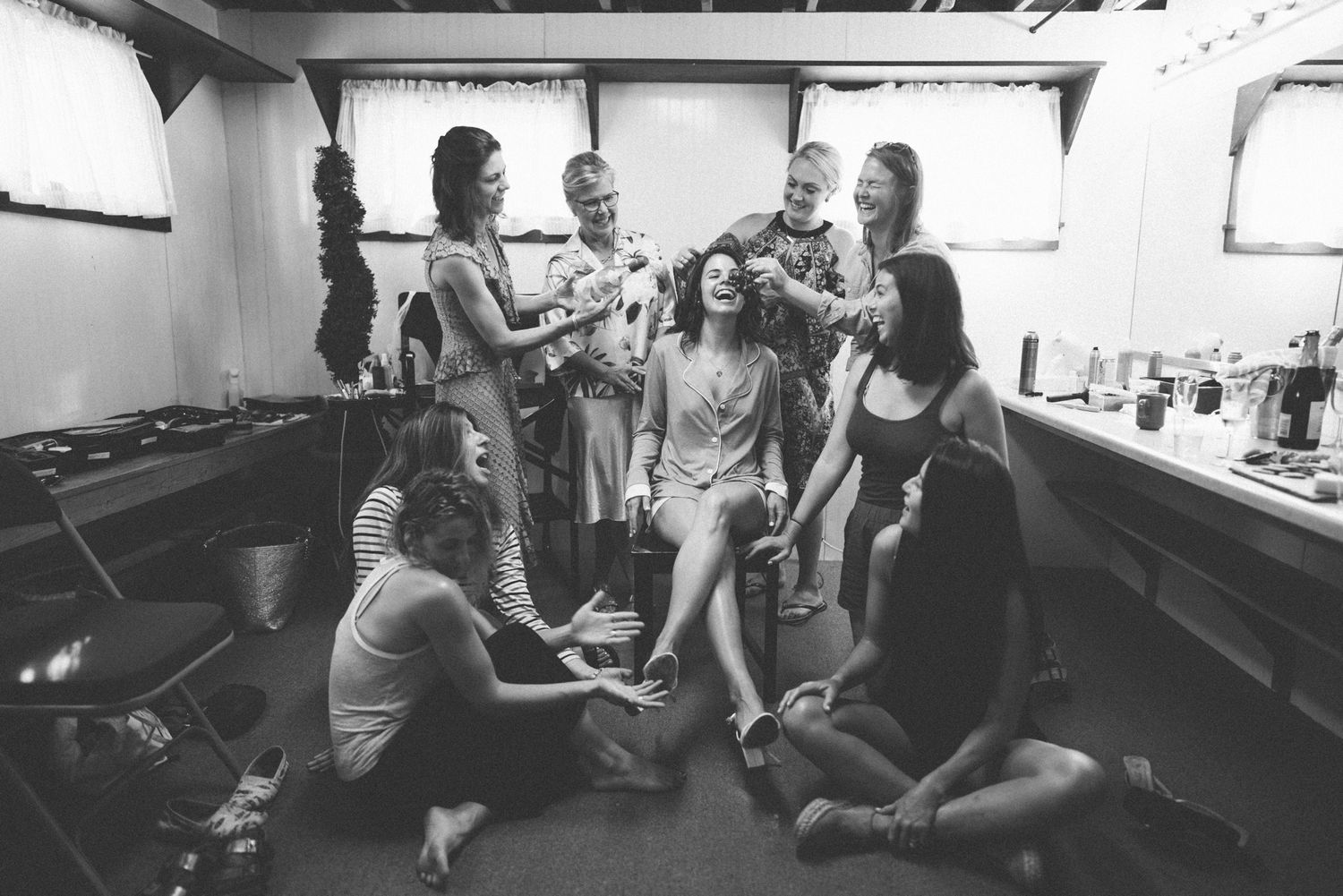 A group of friends gathered in a casual indoor setting sharing drinks and conversation.