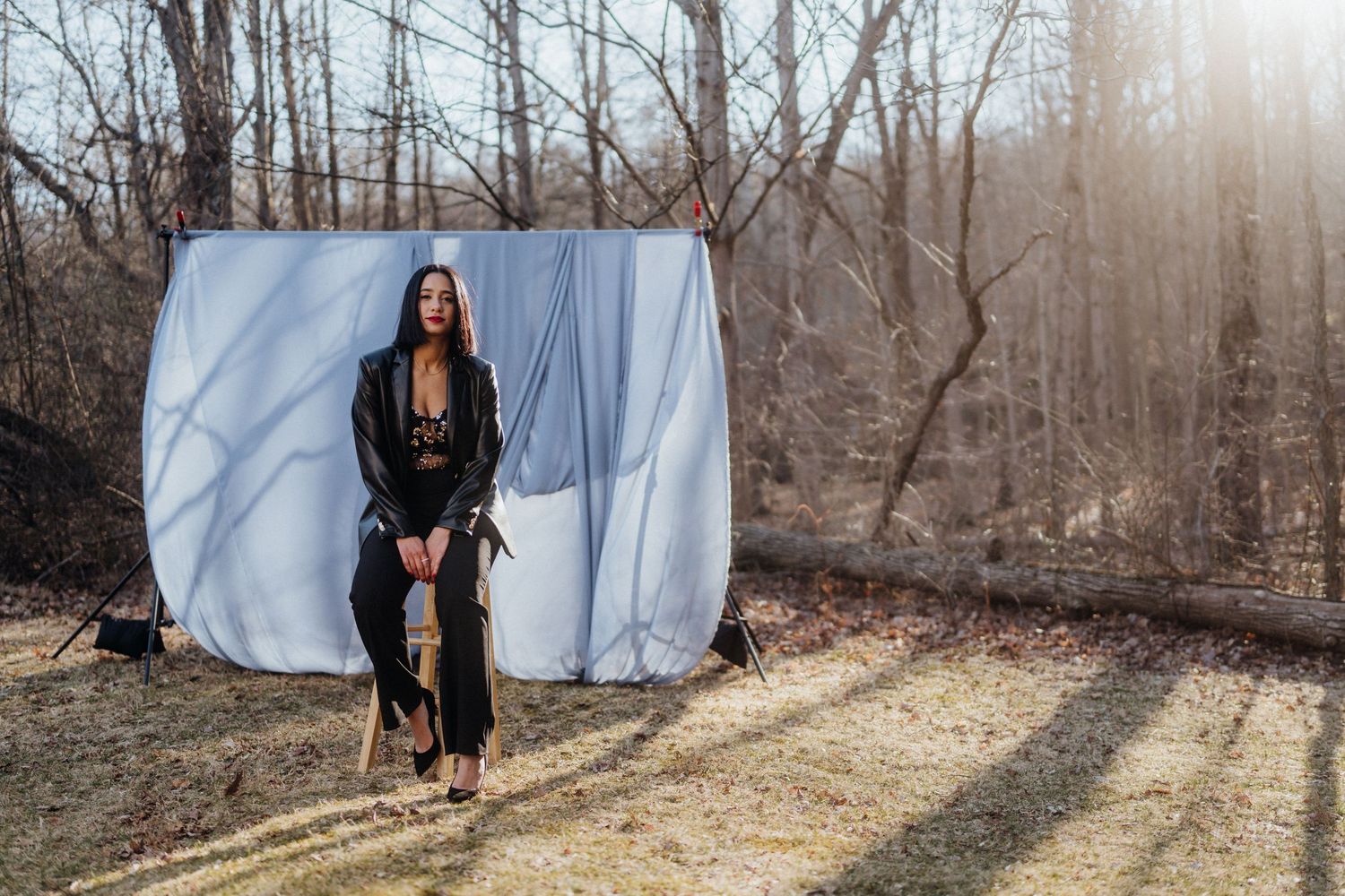 Fashion shoot with white backdrop in winter forest setting.
