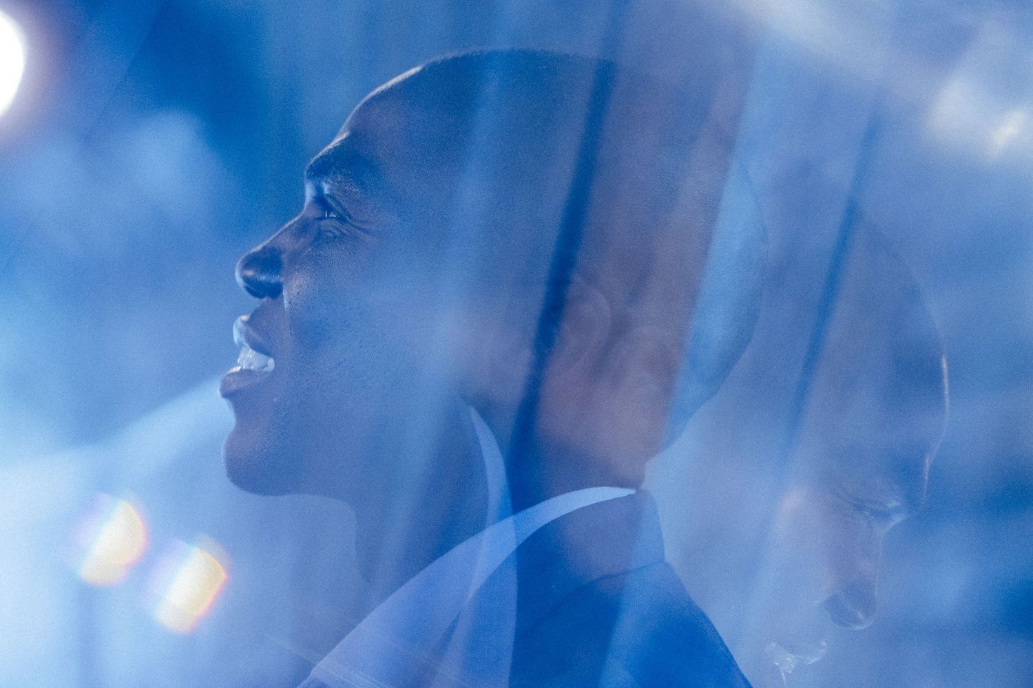 Ethereal profile portrait with blue lighting and bokeh effects.
