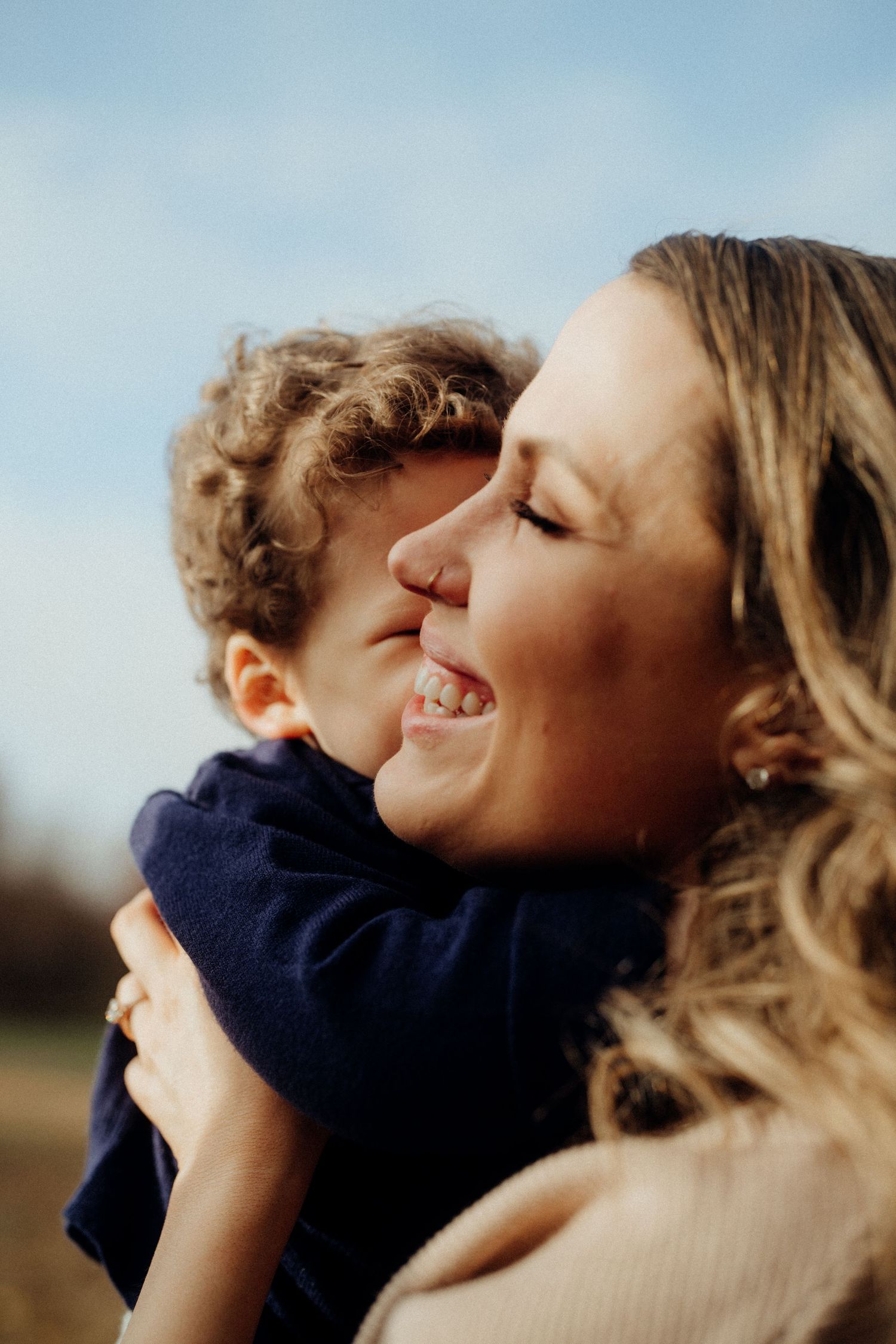 An intimate moment of laughter and embrace captured in golden sunlight.