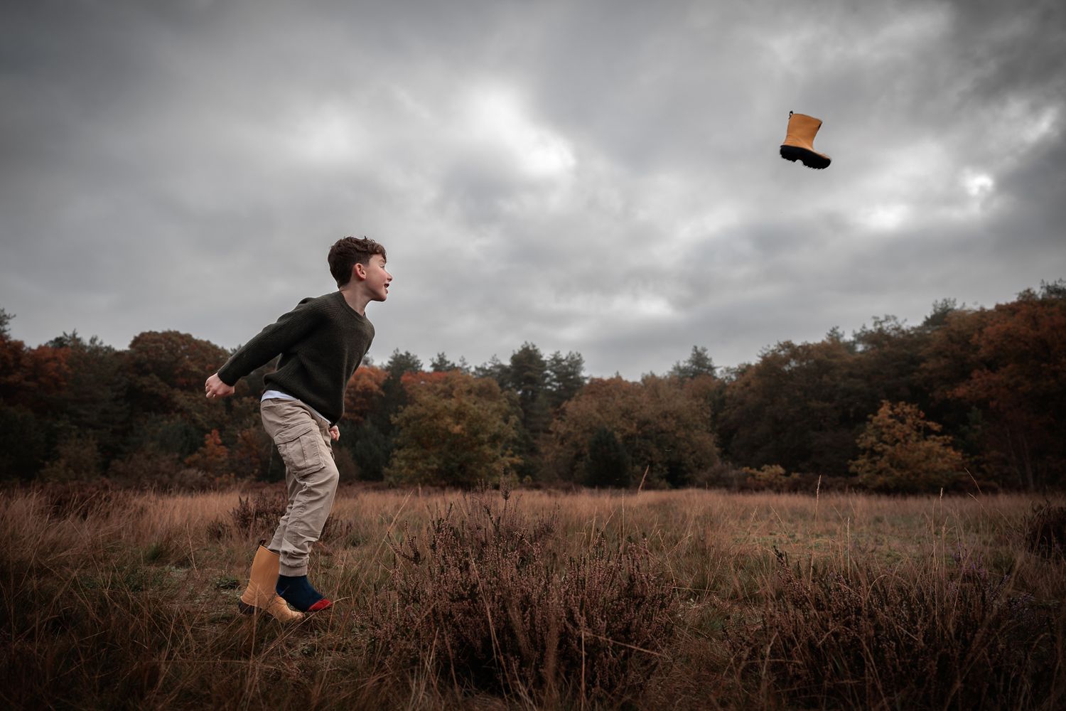 Grappig beeld waarbij kind zijn laars uitschopt welke in de lucht vliegt, precies op het juiste moment gefotografeerd spontante fotograaf