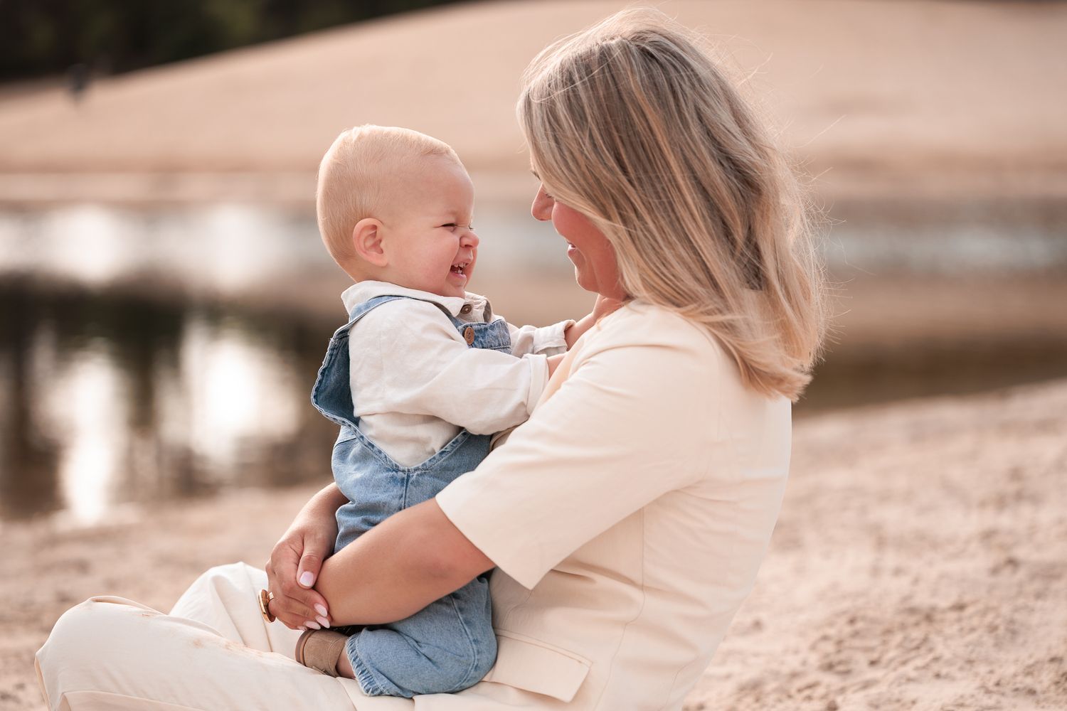 baby kijkt moeder liefdevol aan tijdens fotoshoot aan het water
