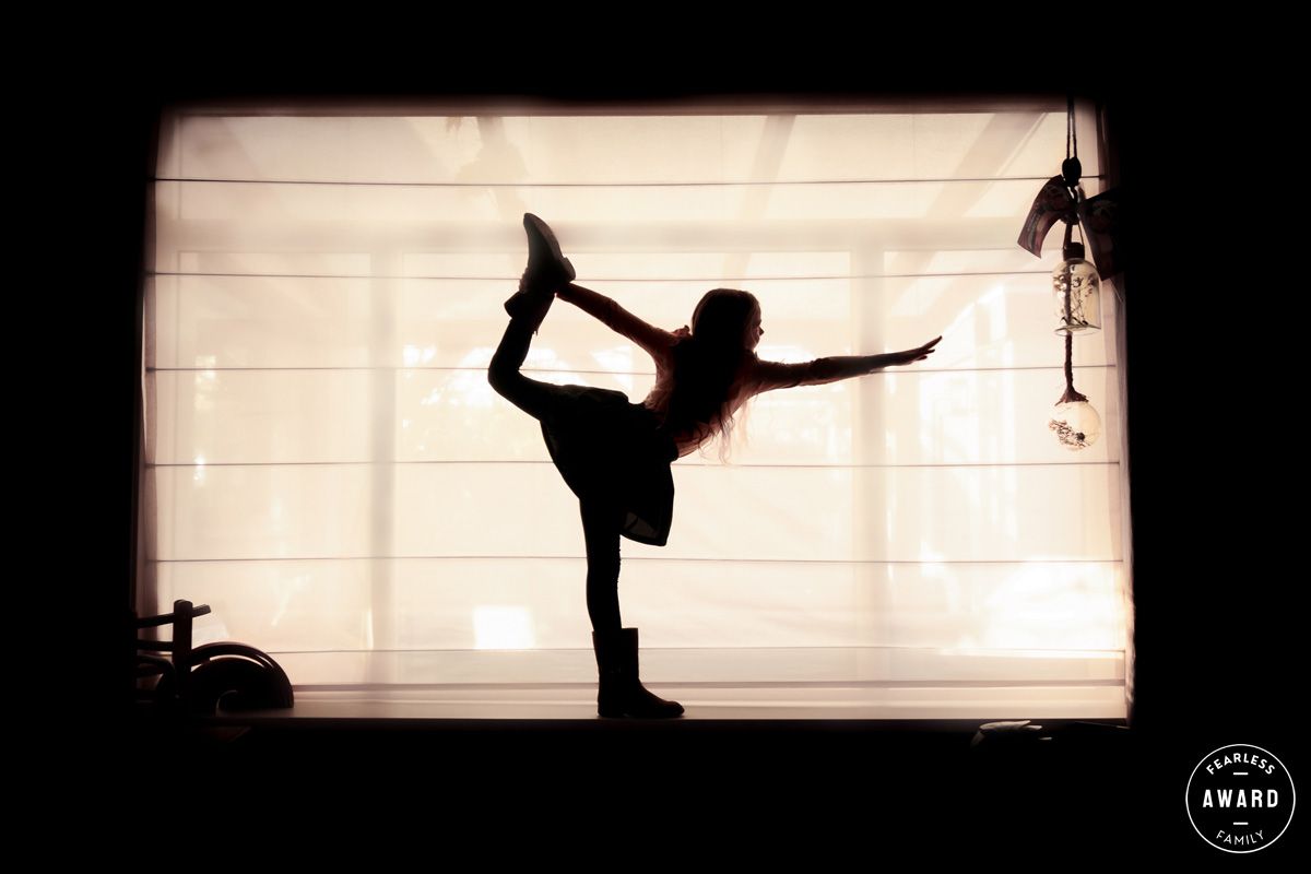 silhouetfoto van kind in ballerinahouding met tegenlicht, internationaal award winnaar