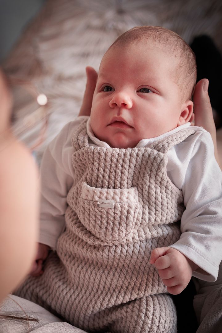 wakkere baby op de handen van zijn moeder, kijkt haar liefdevol aan