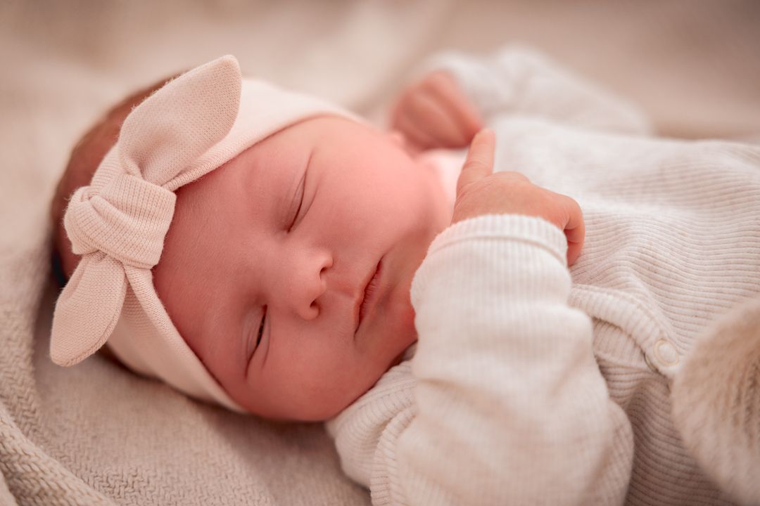 newborn baby met haarhandje in een zacht babymandje tijdens newbornfotoshoot door Fotos van Jess in Brabant aan de grens met Zeeland