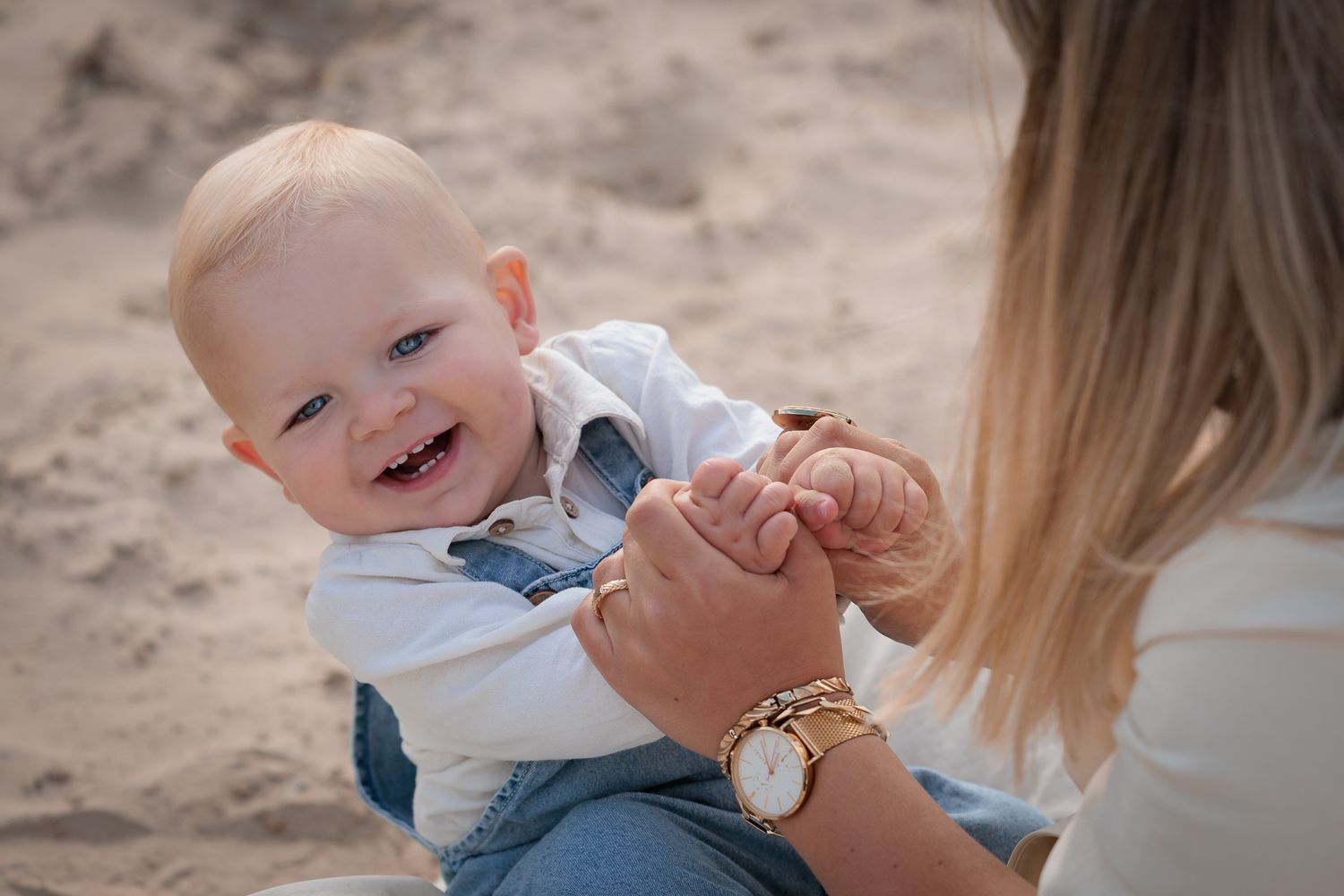 lachende baby tijdens fotoshoot aan het water