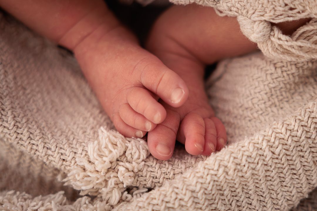 close up van newborn babyvoetjes in een kleedje