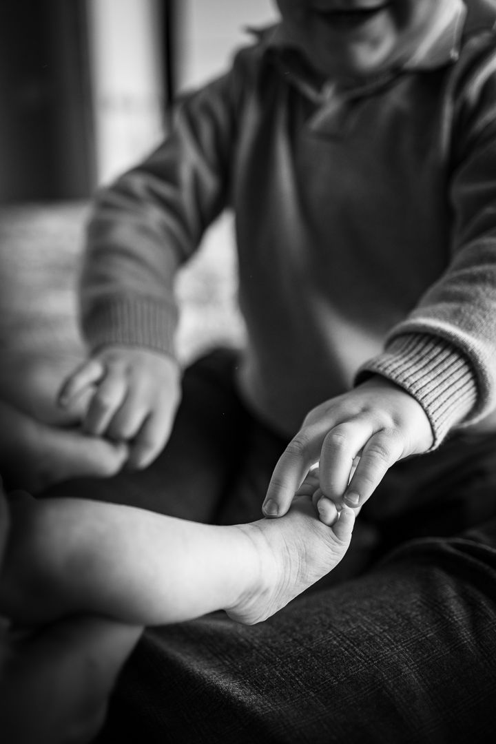 grote broer kietelt de teentjes van zijn babybroertjes