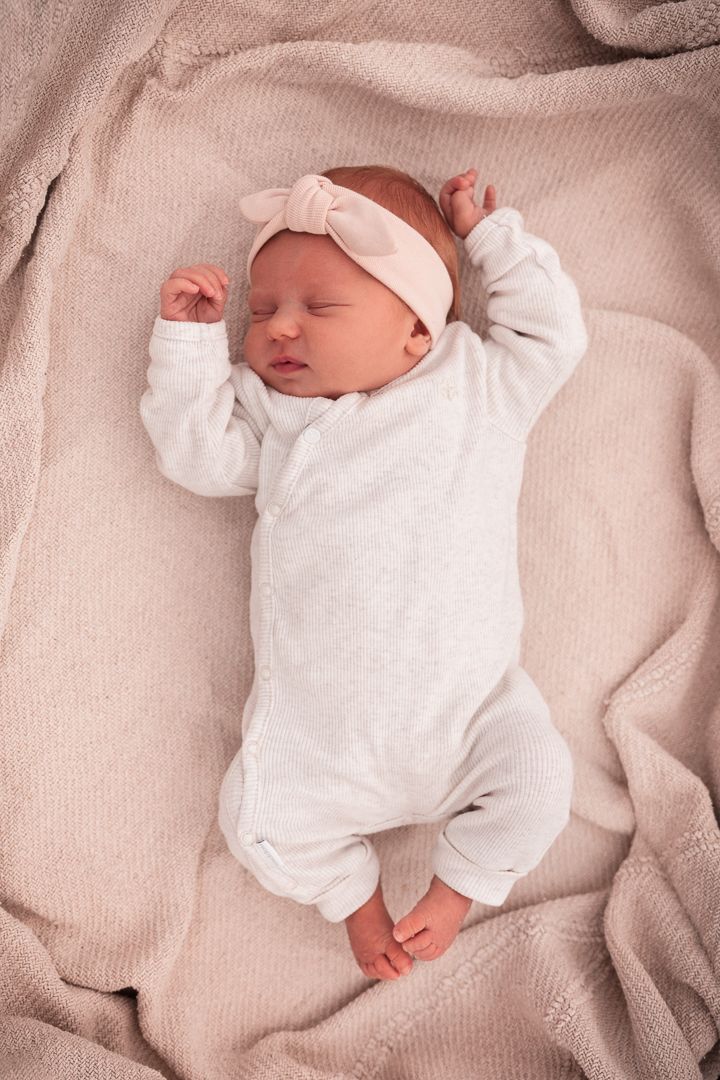 close up van newborn baby in een babymandje op een zacht kleedje buiten fotoshoot