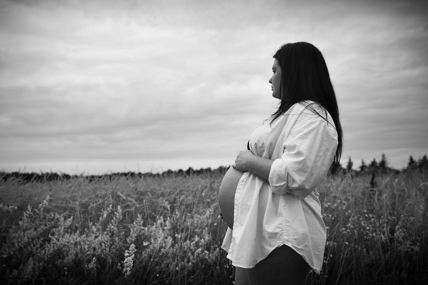intieme foto van zwangere vrouw in de natuur met ontblote buik