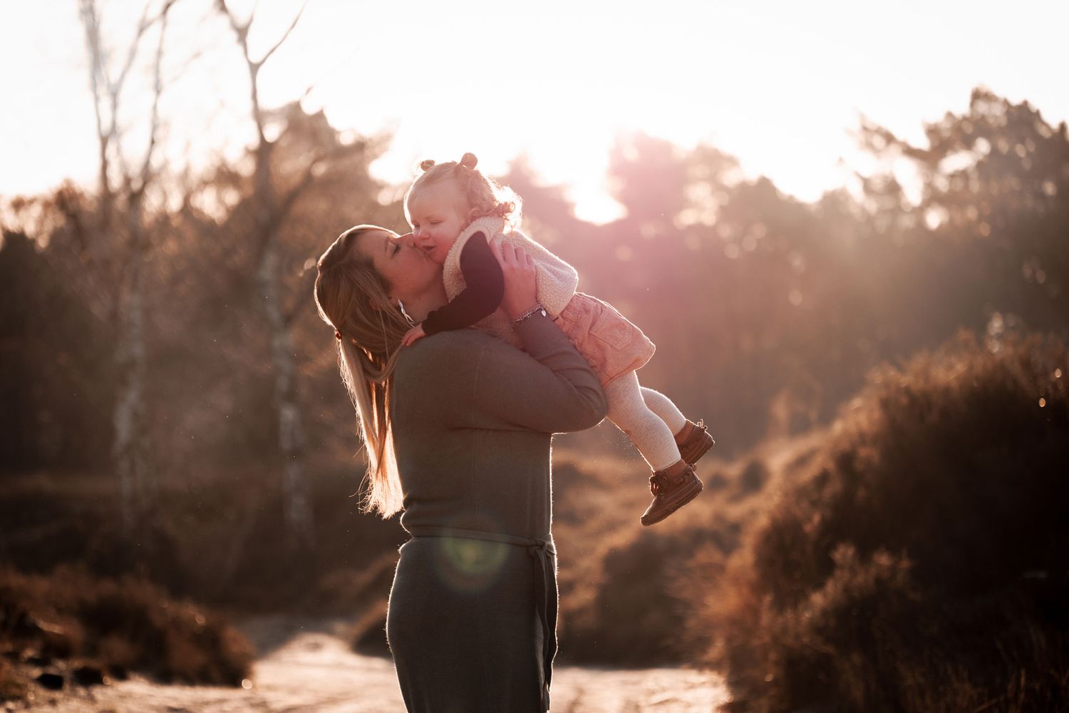 Lief moment tussen moeder en haar dochter die opgetild word en op haar wang wordt gekust