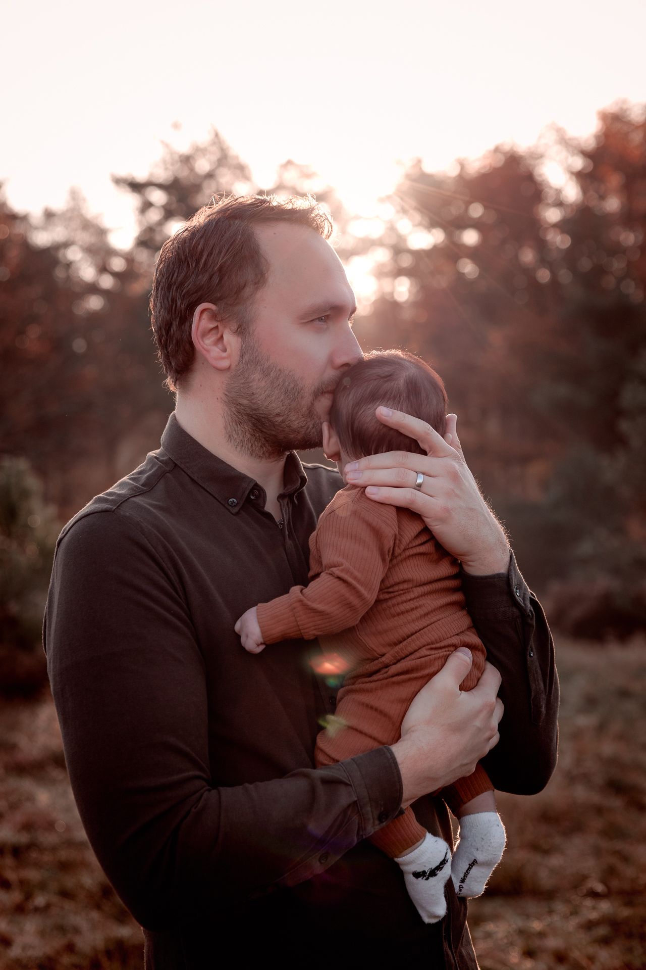 Vader met zijn newborn baby op een buiten fotoshootlocatie in West-Brabant