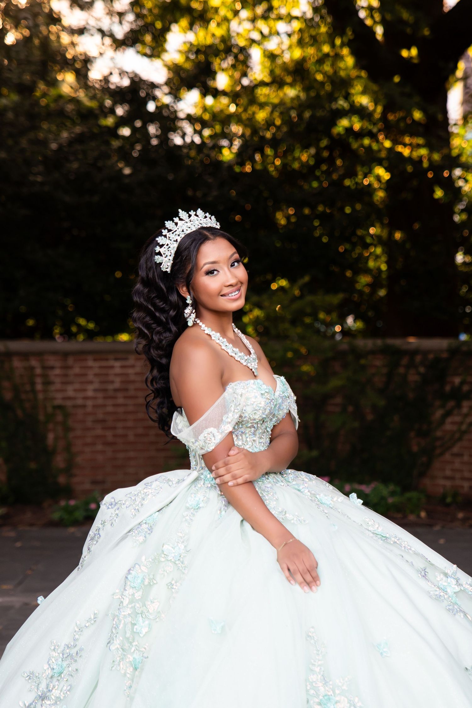 Stunning princess ball gown with intricate details photographed in outdoor garden setting.
