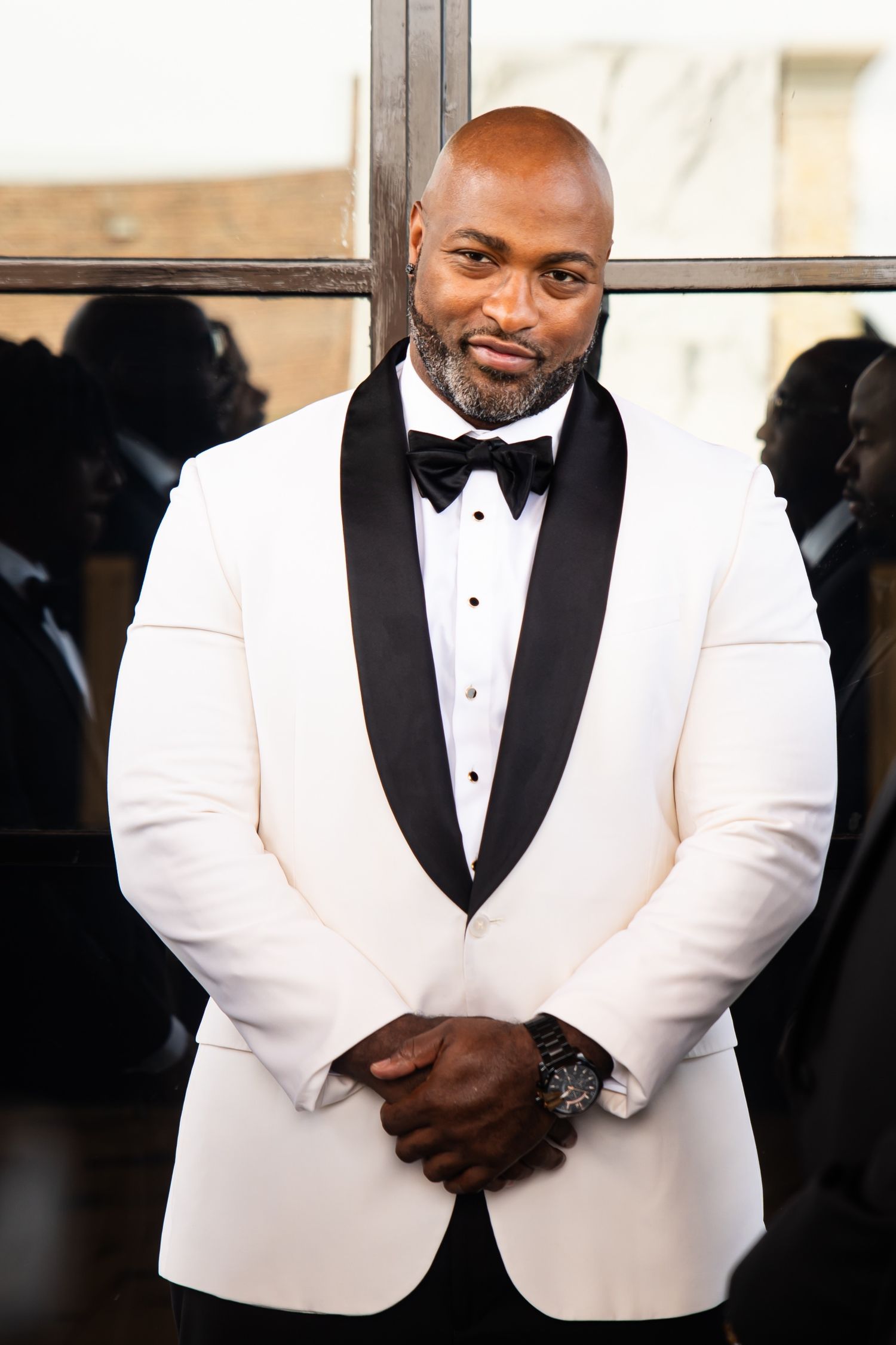 Close-up details of a white tuxedo jacket with black lapels and bowtie.