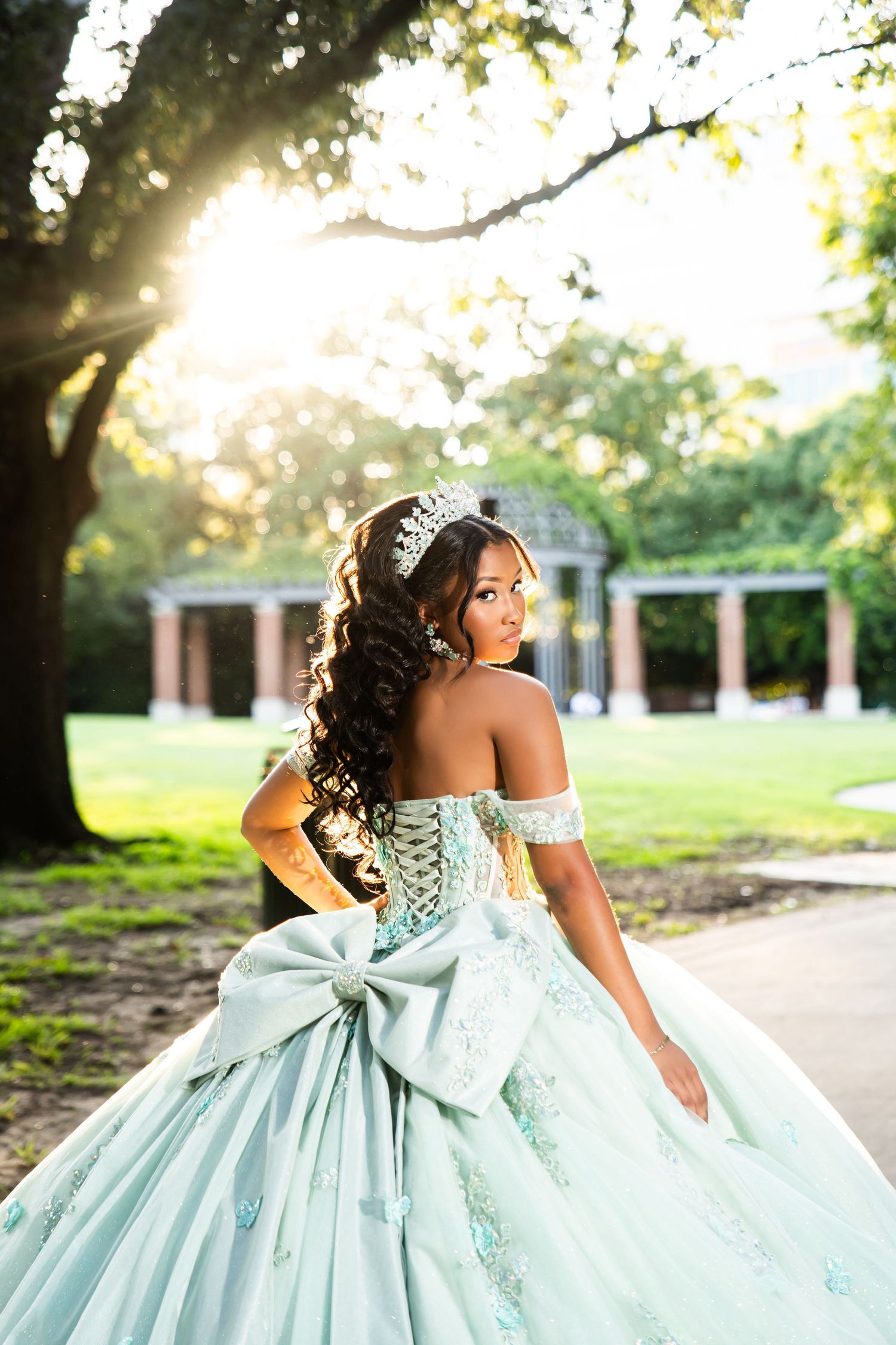Mint green princess gown with dramatic bow detail photographed in natural sunset lighting.