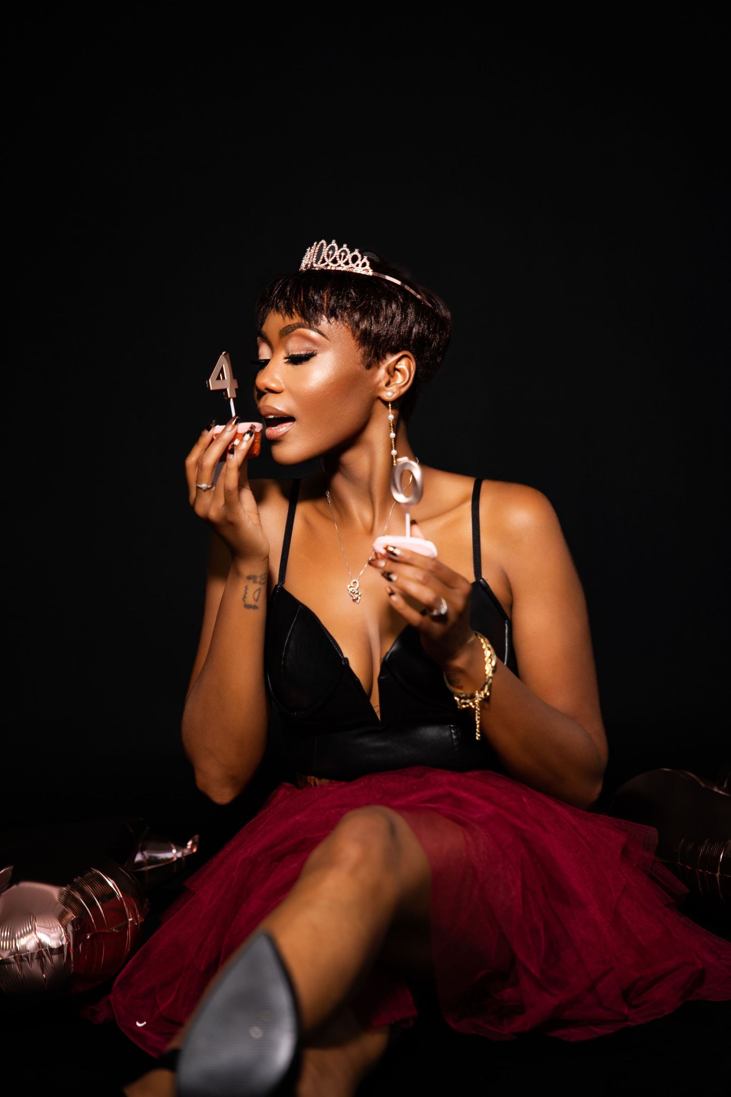 Glamour portrait series with burgundy tulle dress against dark background.