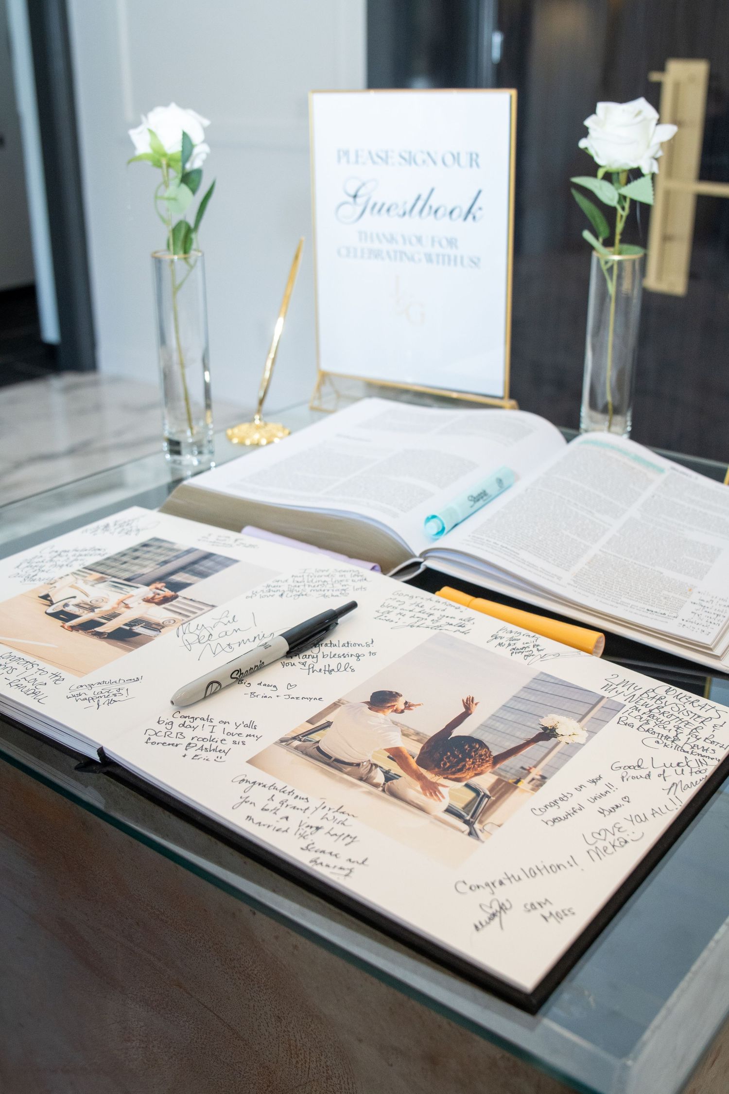 Wedding guest book display with pen and photographs ready for signatures.